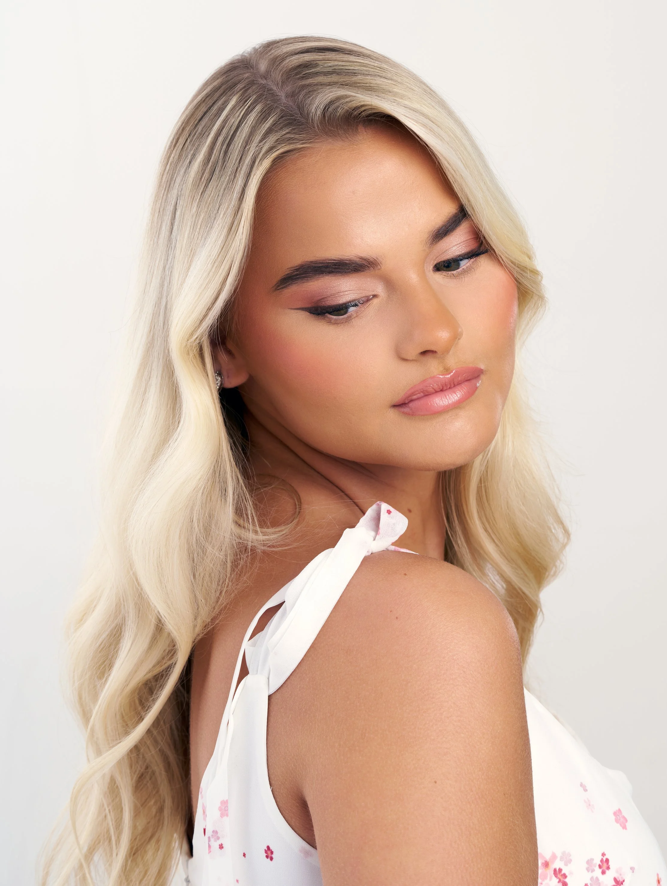 Bleach blonde women looking at camera with bridal makeup looking down