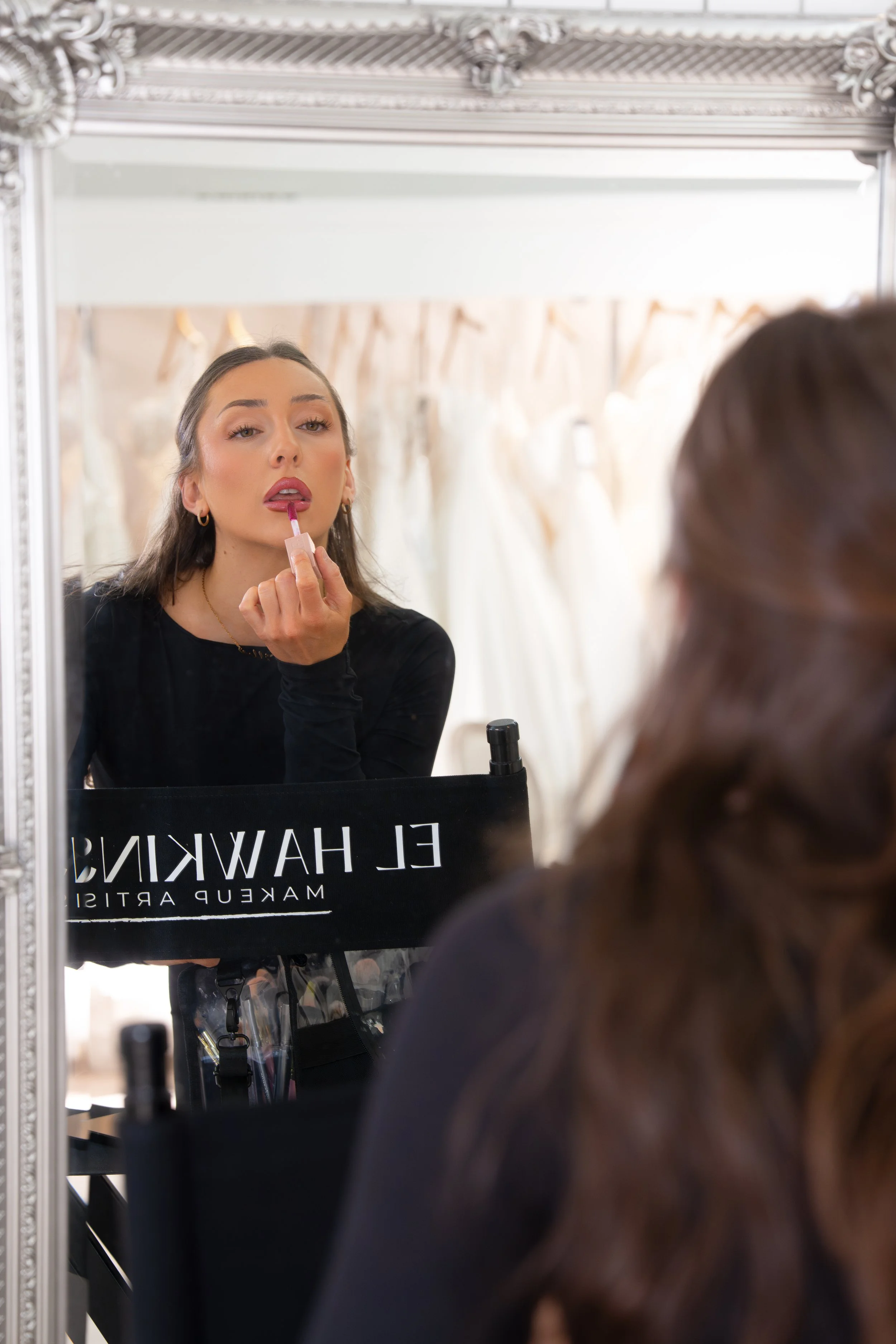 Birmingham bridal makeup artist applying lipstick in a makeup mirror