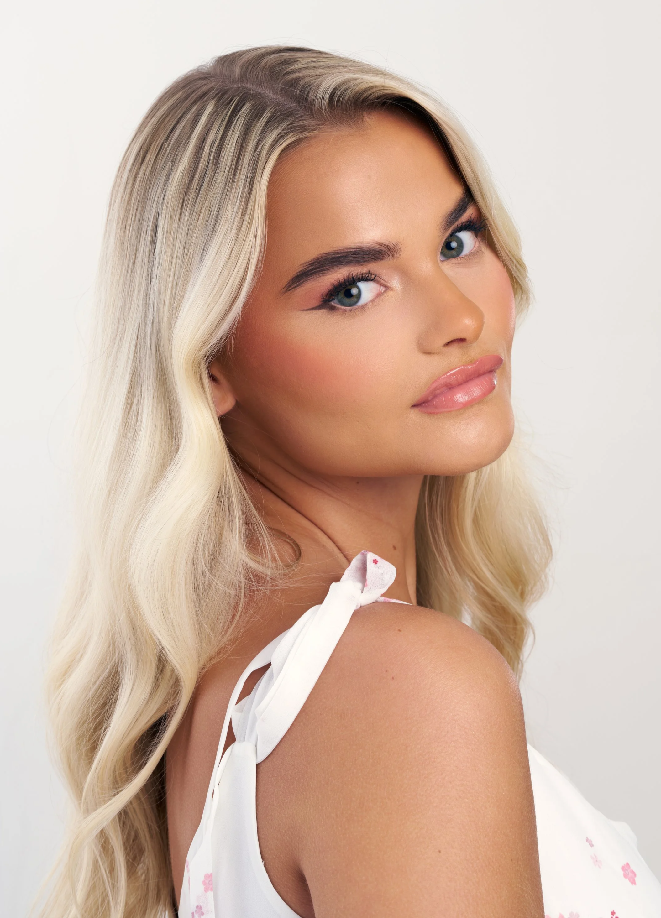 Bleach blonde women looking at camera with bridal makeup on