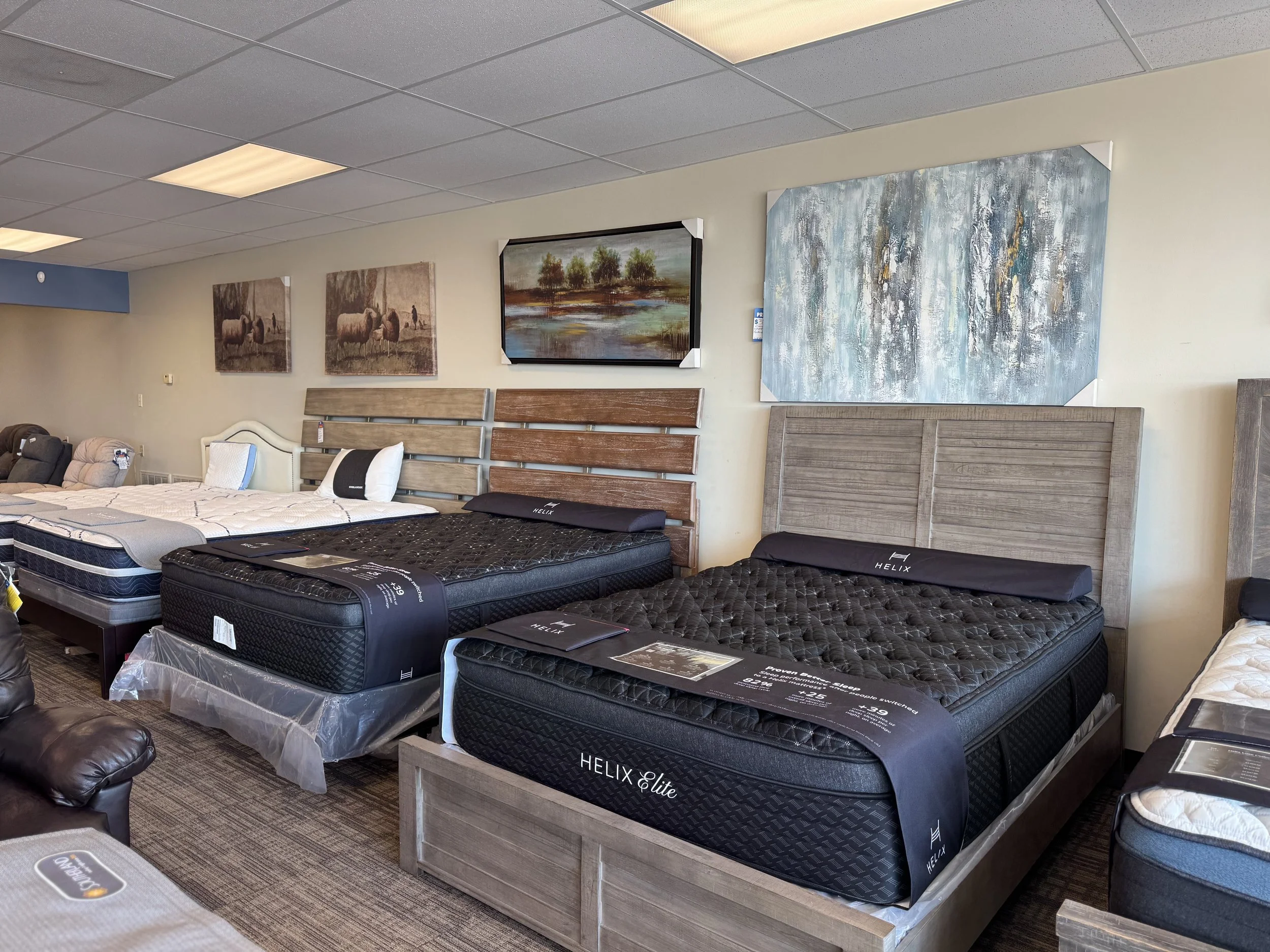 Showroom display of various mattresses and bed frames in a furniture store.