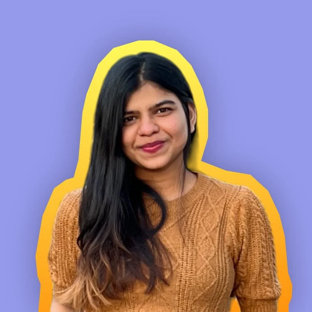A woman with long black hair, wearing a brown textured sweater, smiling, with a yellow outline around her head and shoulders against a purple background.