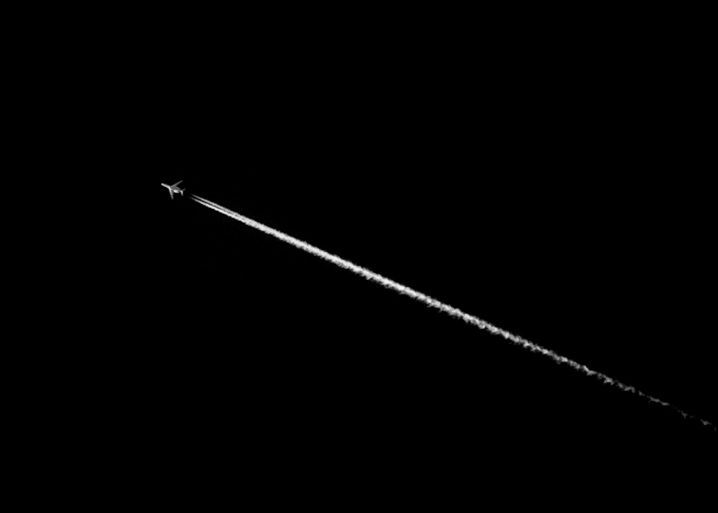 Aircraft contrail showing flight path directly over houses - property buyers should check aviation exposure before purchasing