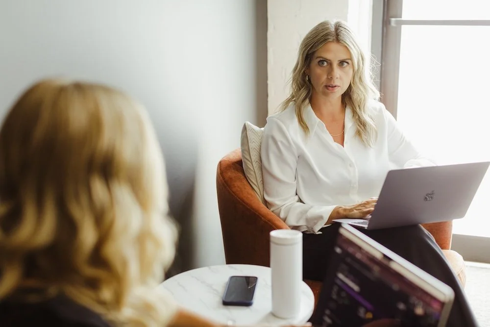 Women have conversation with laptops in work setting