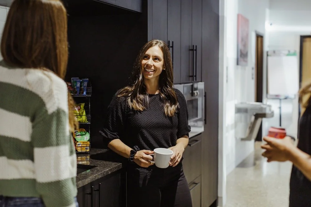 Coworkers have a conversation at the kitchen