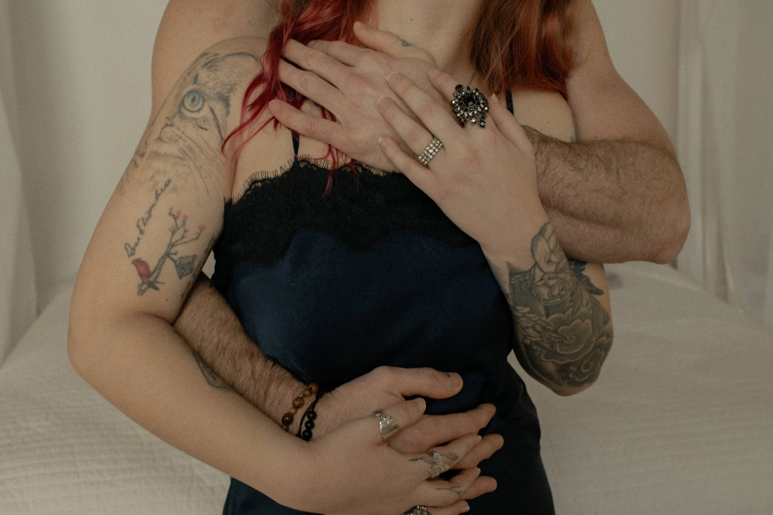 he/him & she/her hands wrapped around her body in a close cuddle way for couples boudoir photography.