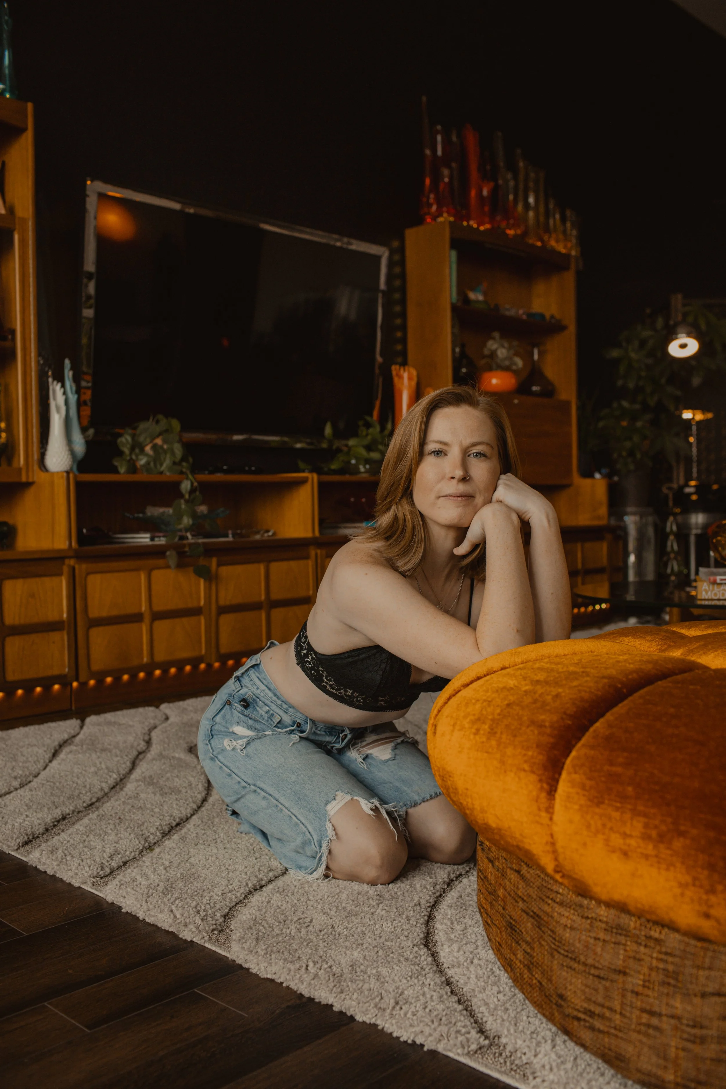 girl posing in living room in jeans for boudoir session