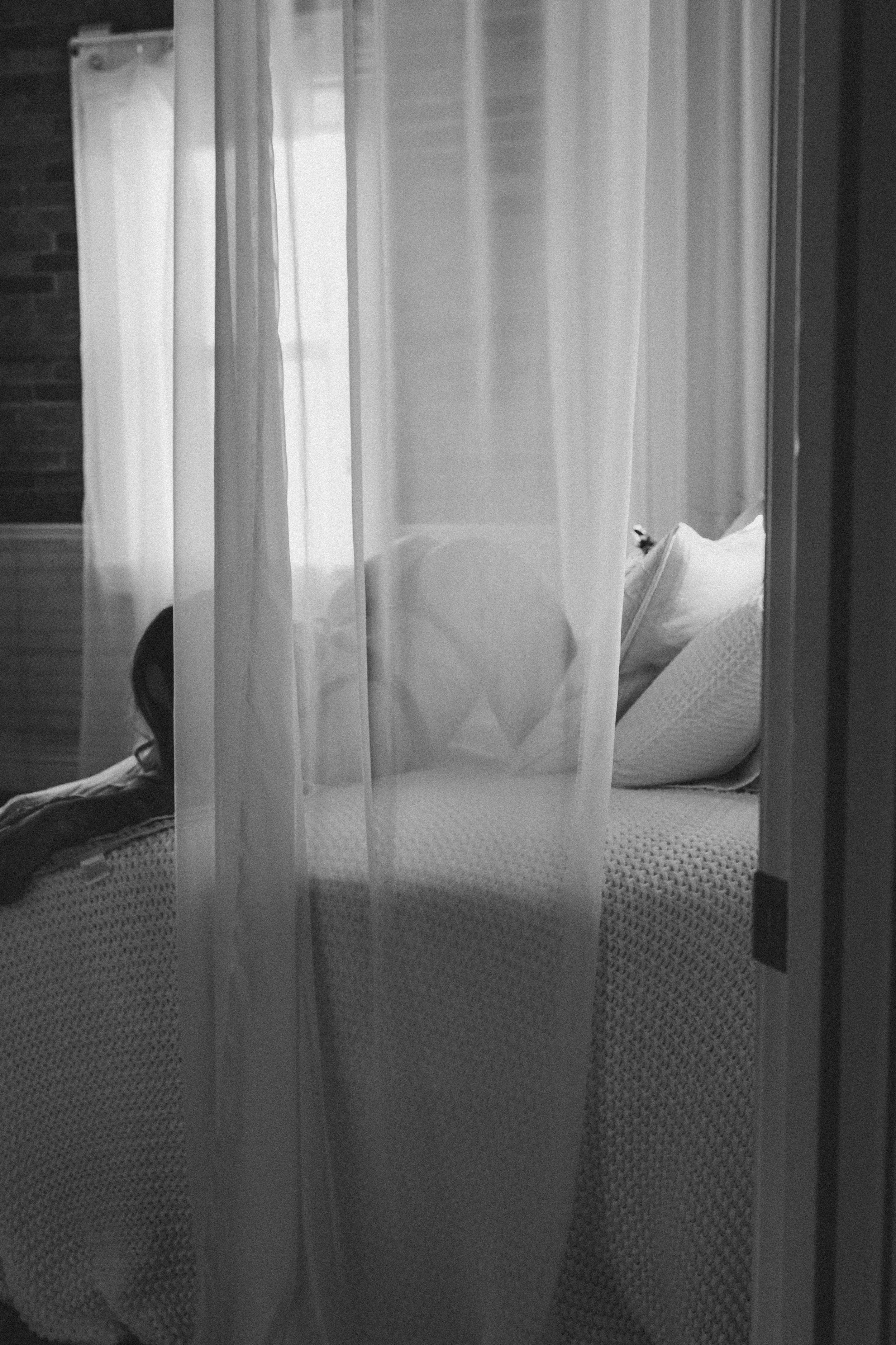 Boudoir client in black & white image sultry sheet covering boudoir pose