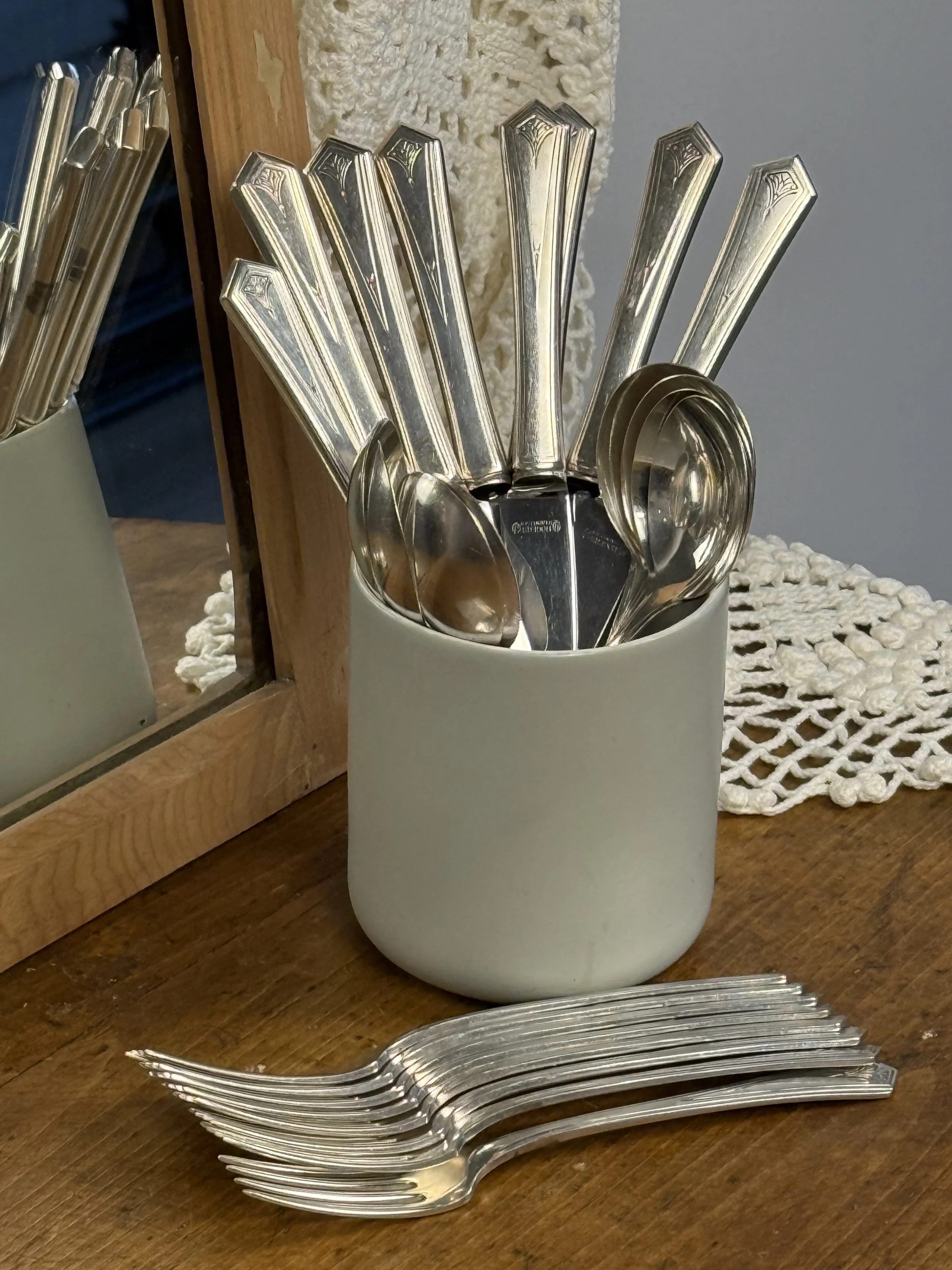 Vintage WM A Rogers silver-plated flatware set styled on wooden table, Art Deco handles, forks knives and spoons