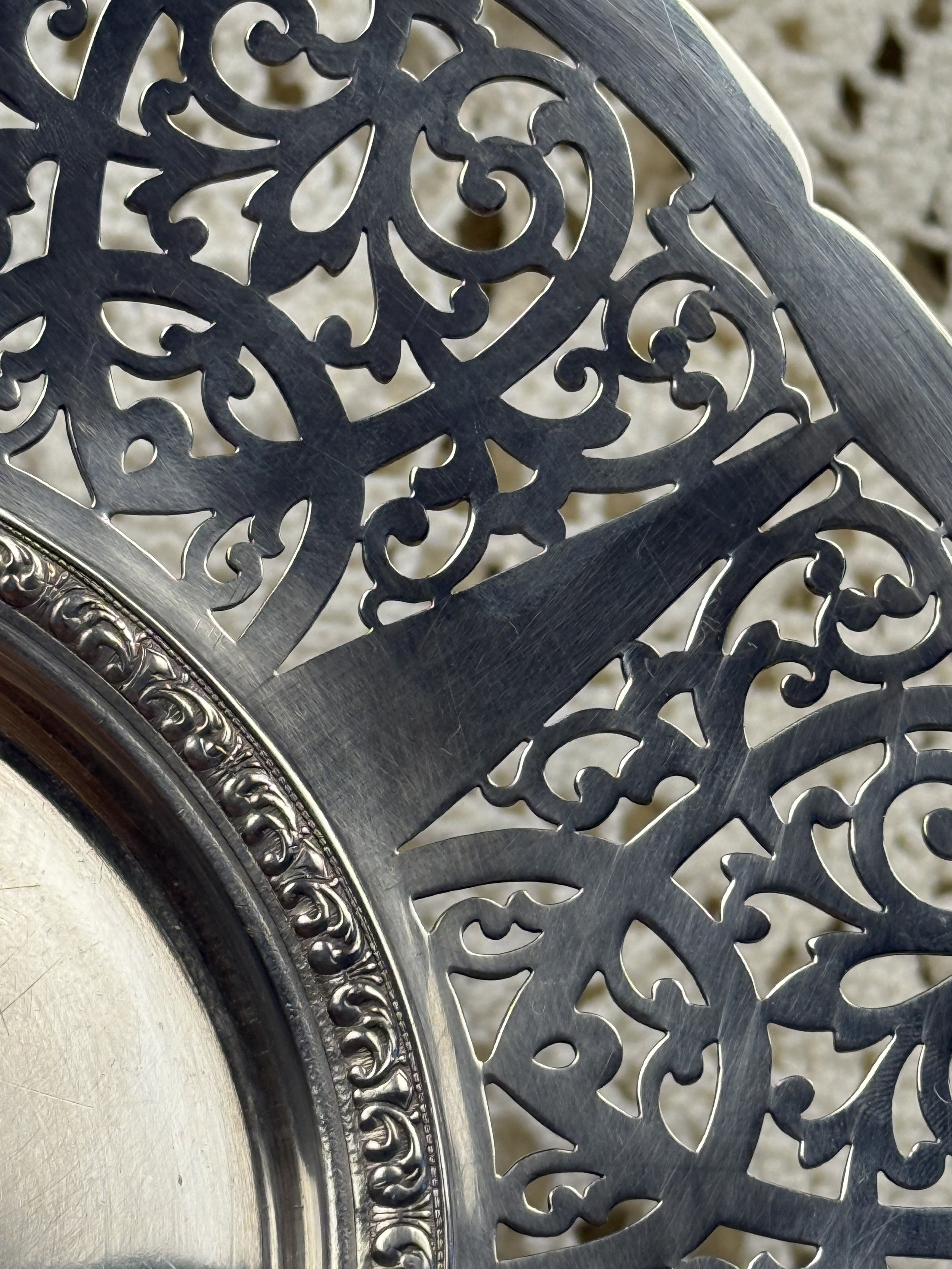 Detailed view of pierced silverplate rim showing intricate scrollwork cutouts and decorative banding on vintage Birks serving plate