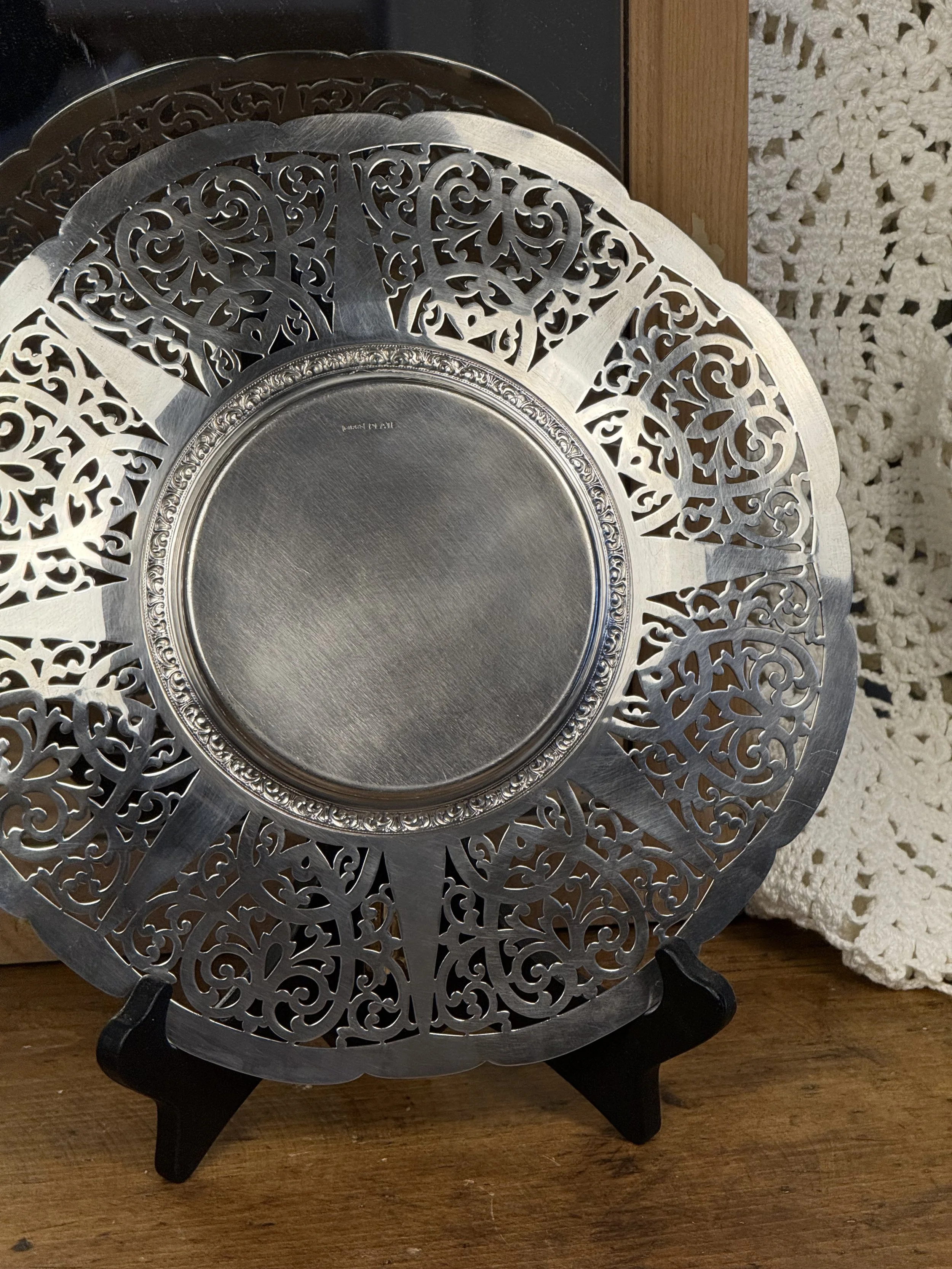 Back angled view of vintage Birks pierced silverplate plate emphasizing radial pierced sections and polished central basin