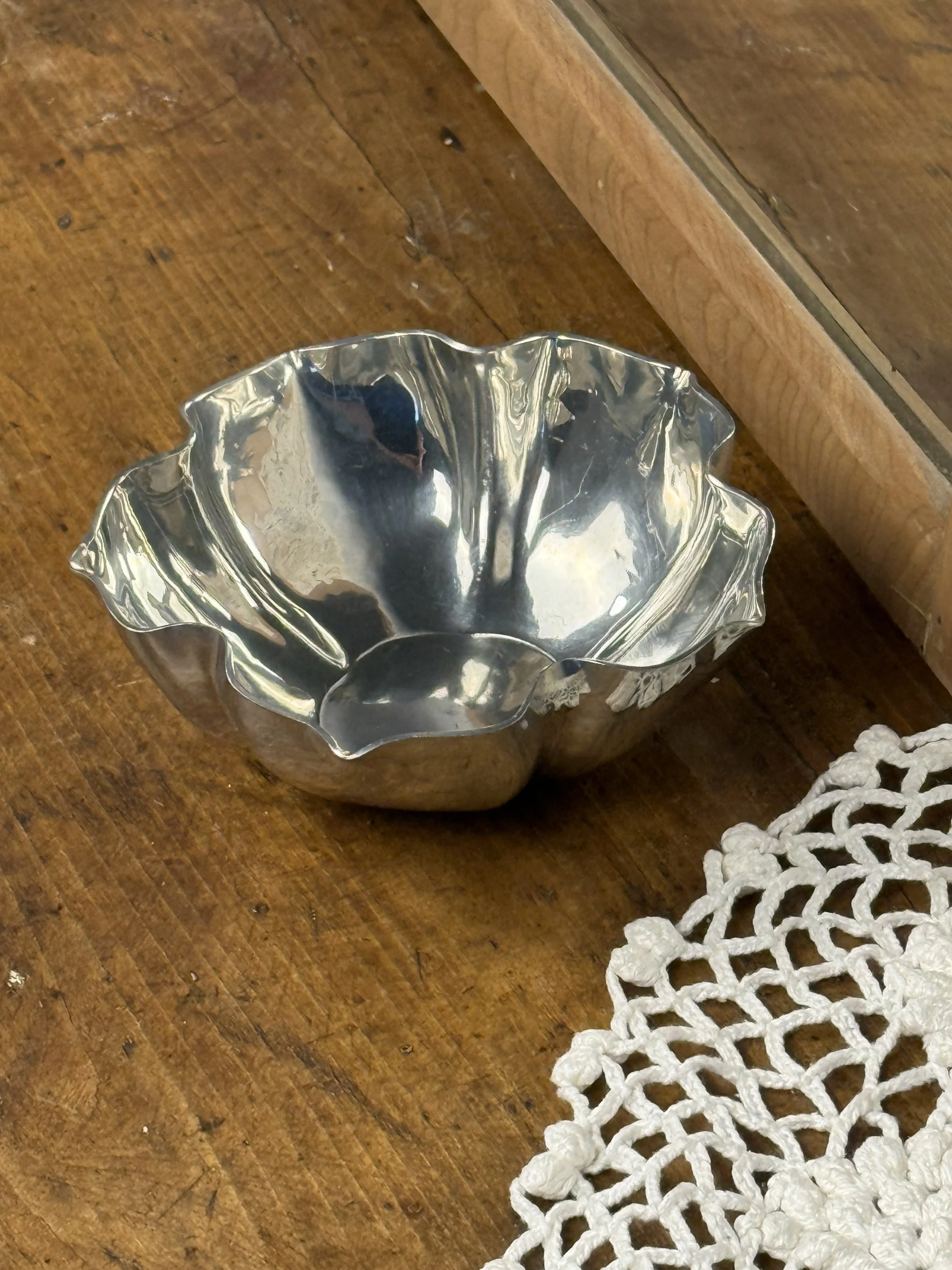 Angled side view of vintage silver decorative bowl highlighting sculptural fluted silhouette and shallow basin