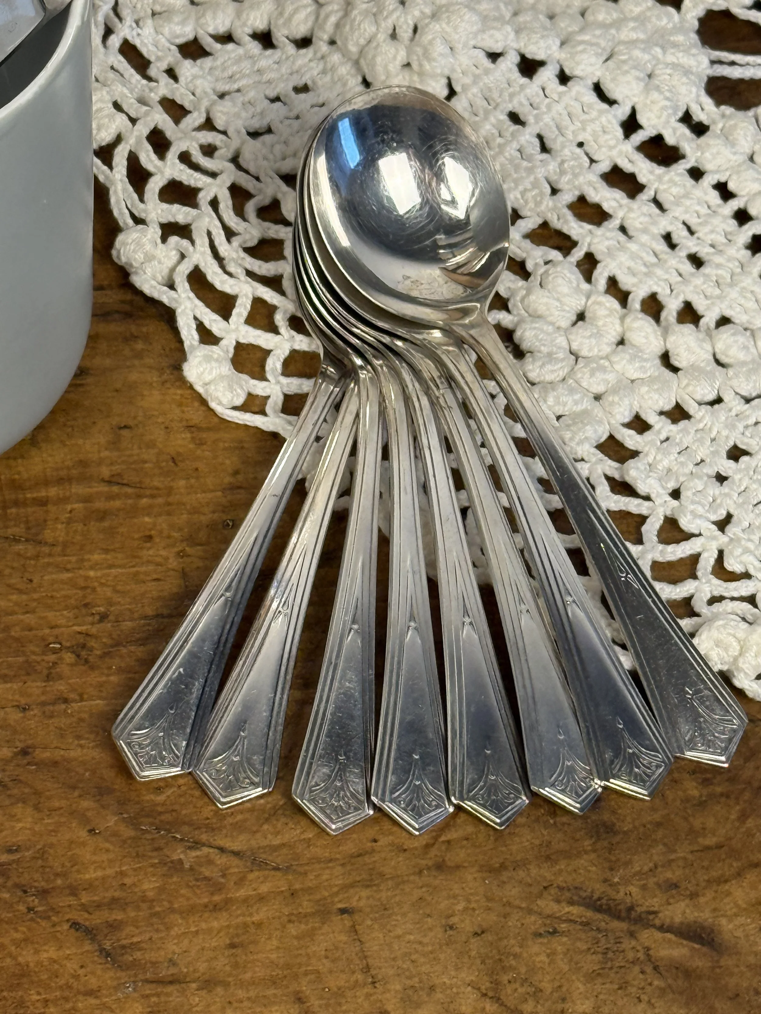 Vintage WM A Rogers teaspoons stacked on wood surface, silver-plated stainless steel flatware