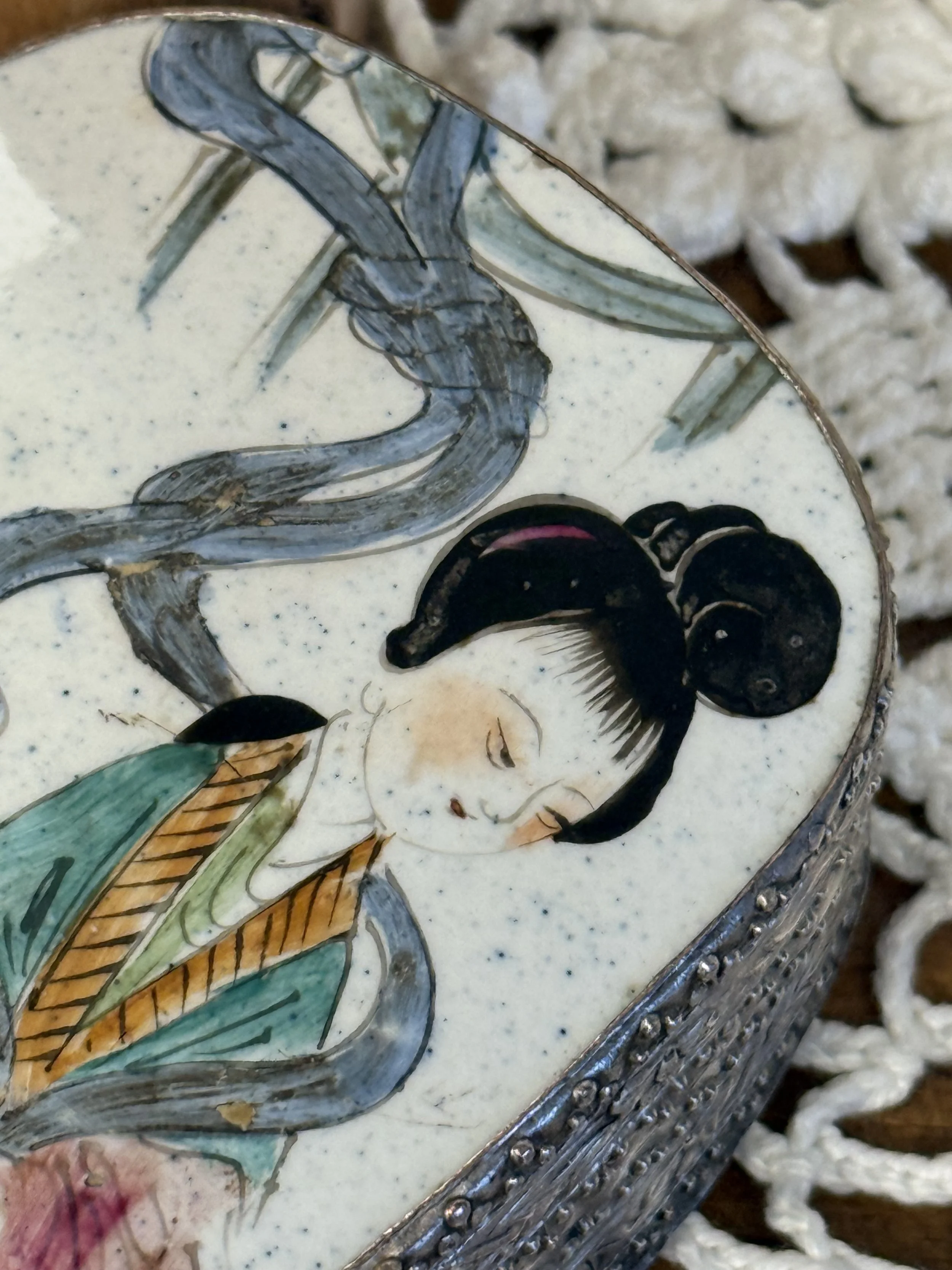 Detailed hand-painted porcelain lid depicting a traditional Asian female figure beneath bamboo branches, soft blue smoke accents, pastel green and rose tones, vintage export-style ceramic artwork