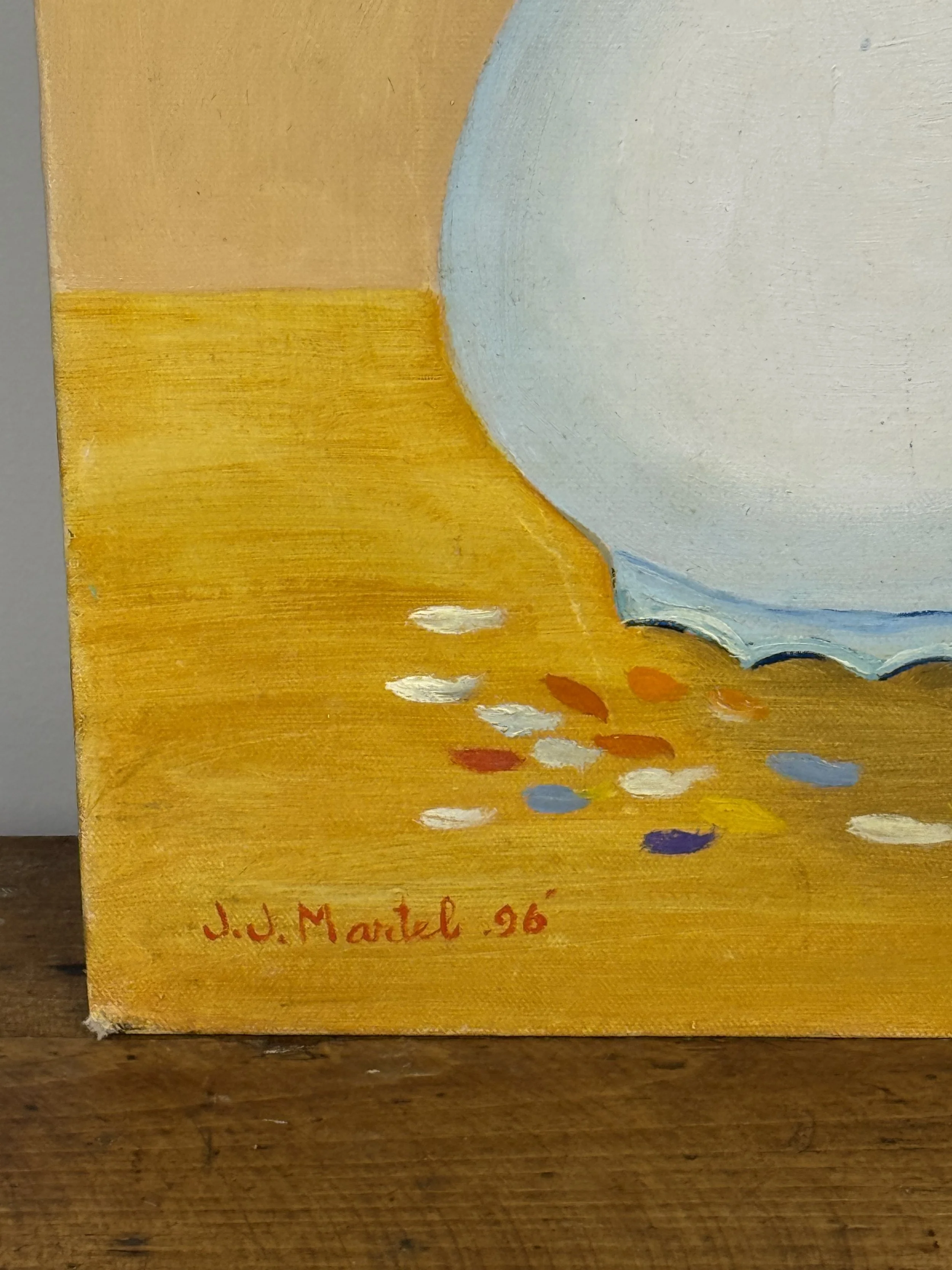 Close-up of J.J. Martel’s 1996 signature on a naïve folk art oil painting with a pale vase and scattered impasto flower petals on an ochre surface