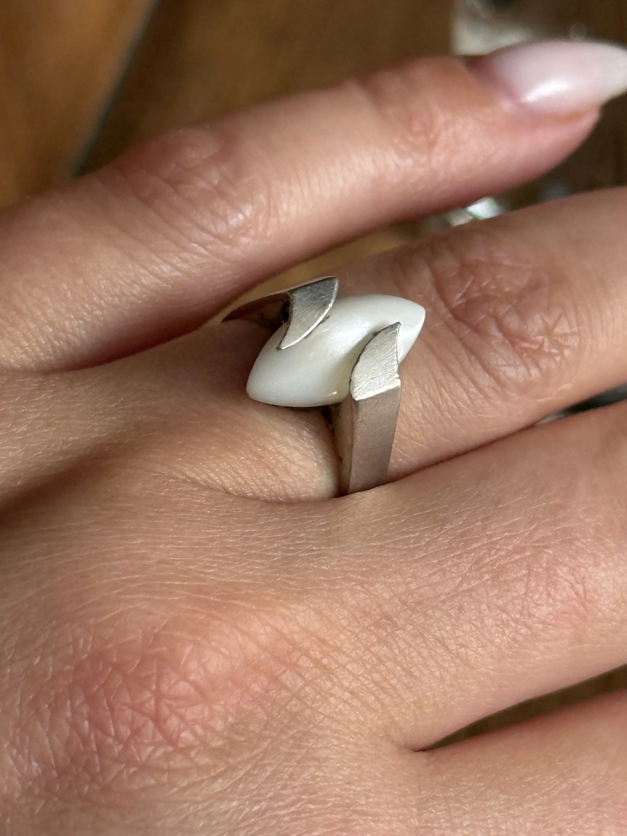Side view of vintage silver ring worn on hand, featuring an elongated white stone and angular modernist prongs, handcrafted minimalist statement ring