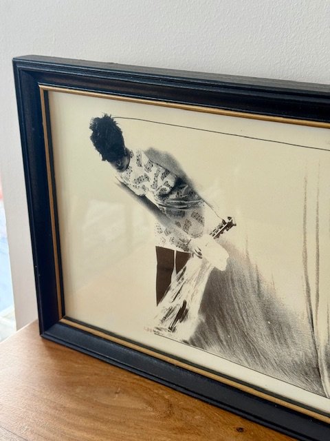 Detail of black wood frame with gold inner edge surrounding vintage abstract artwork, clean linear profile with subtle patina