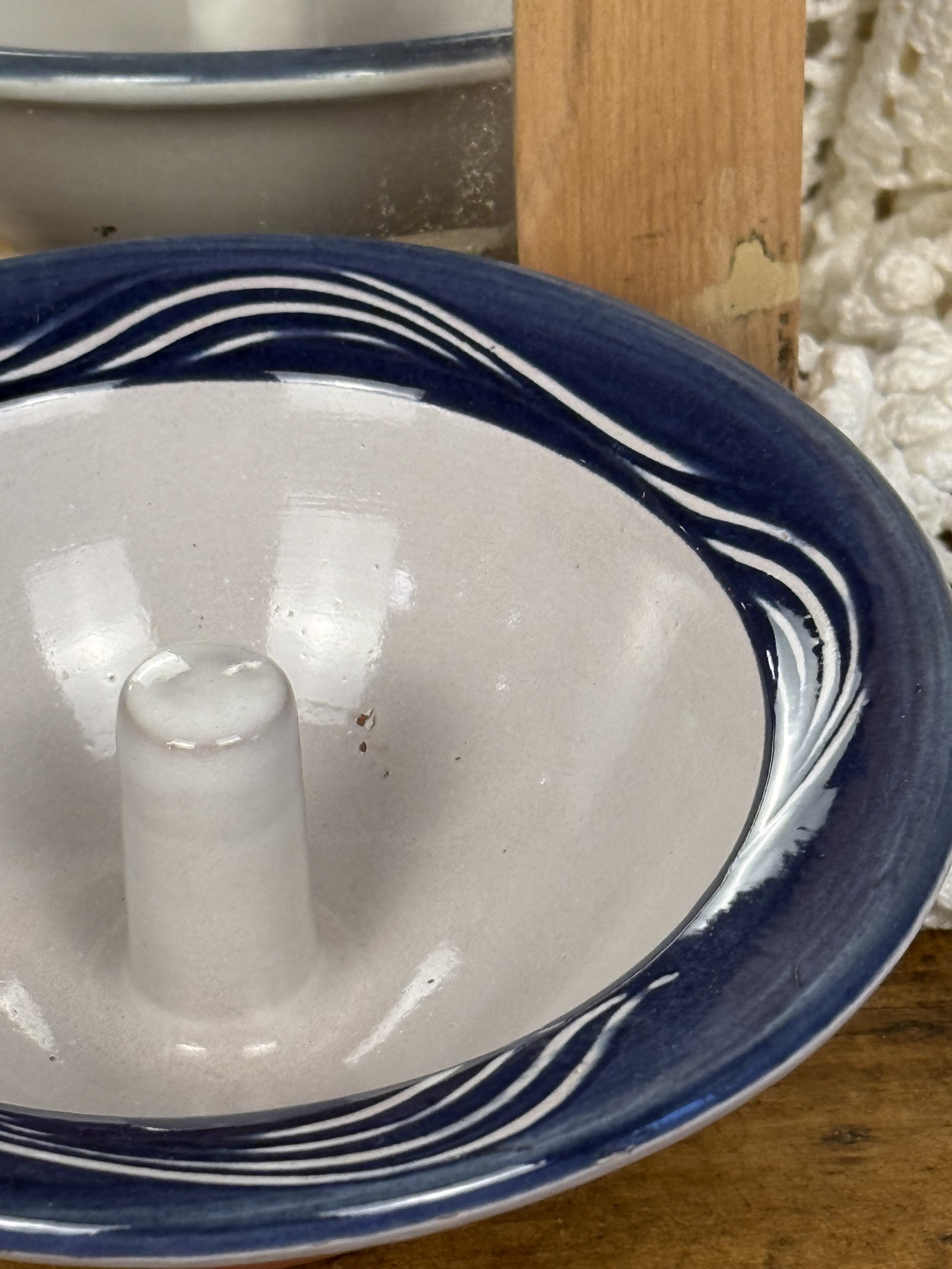 Close-up of glazed interior of vintage terracotta apple baker, raised center chimney, smooth easy-wipe glaze with minor firing speckling, rustic studio utility pottery