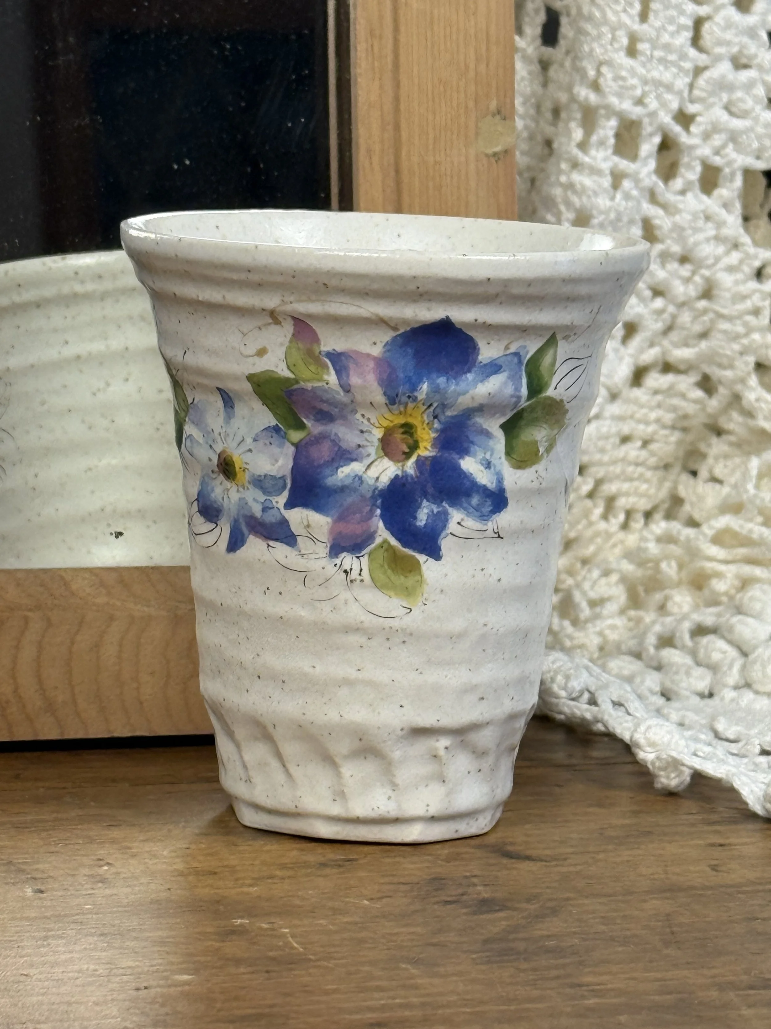 Front view of Japanese stoneware vase with tapered form, textured horizontal ridges, and delicate floral painting, neutral rustic pottery aesthetic
