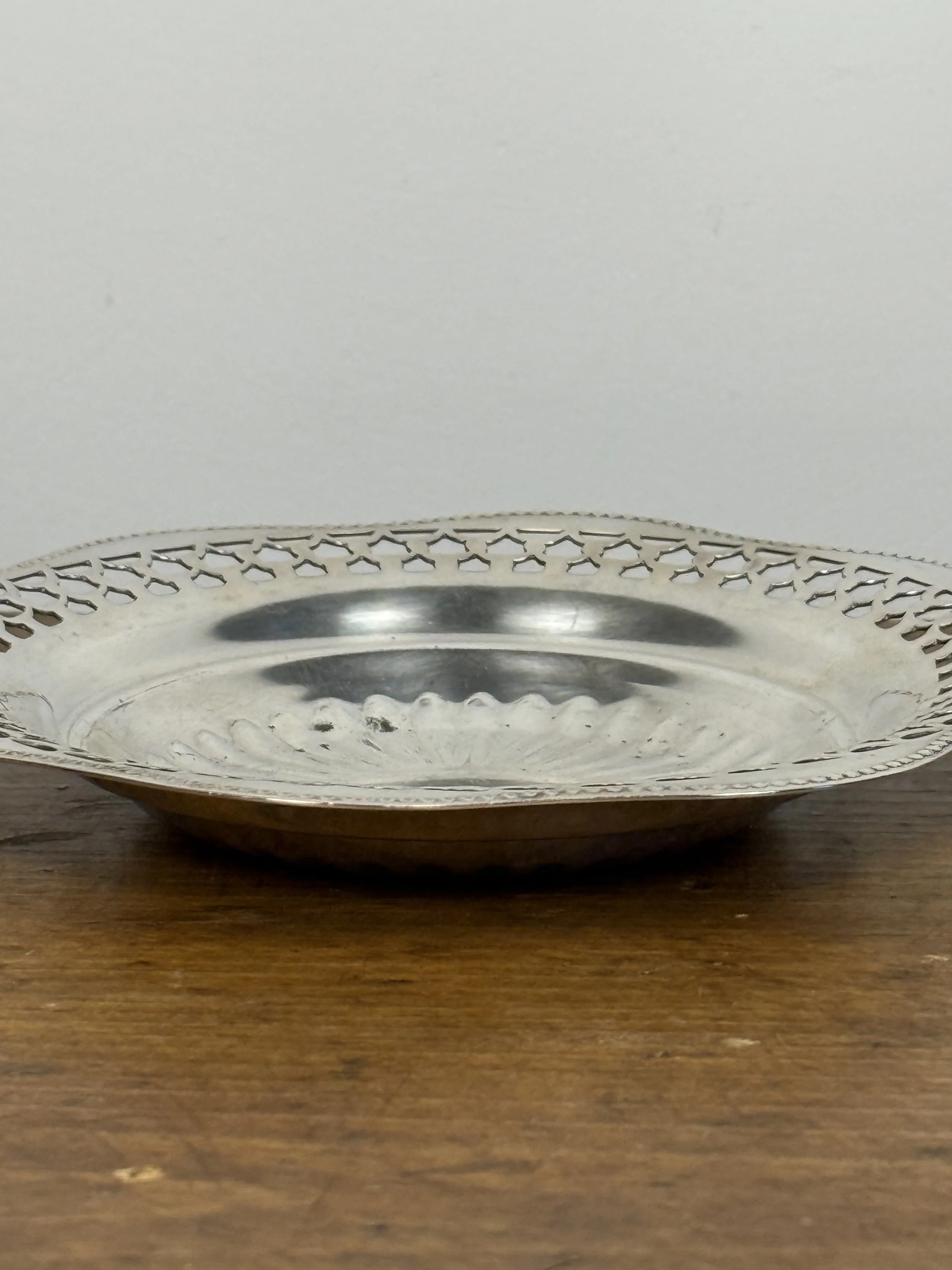 Side profile of vintage EP Copper Viking Plate silverplate serving dish highlighting shallow bowl form and pierced edge