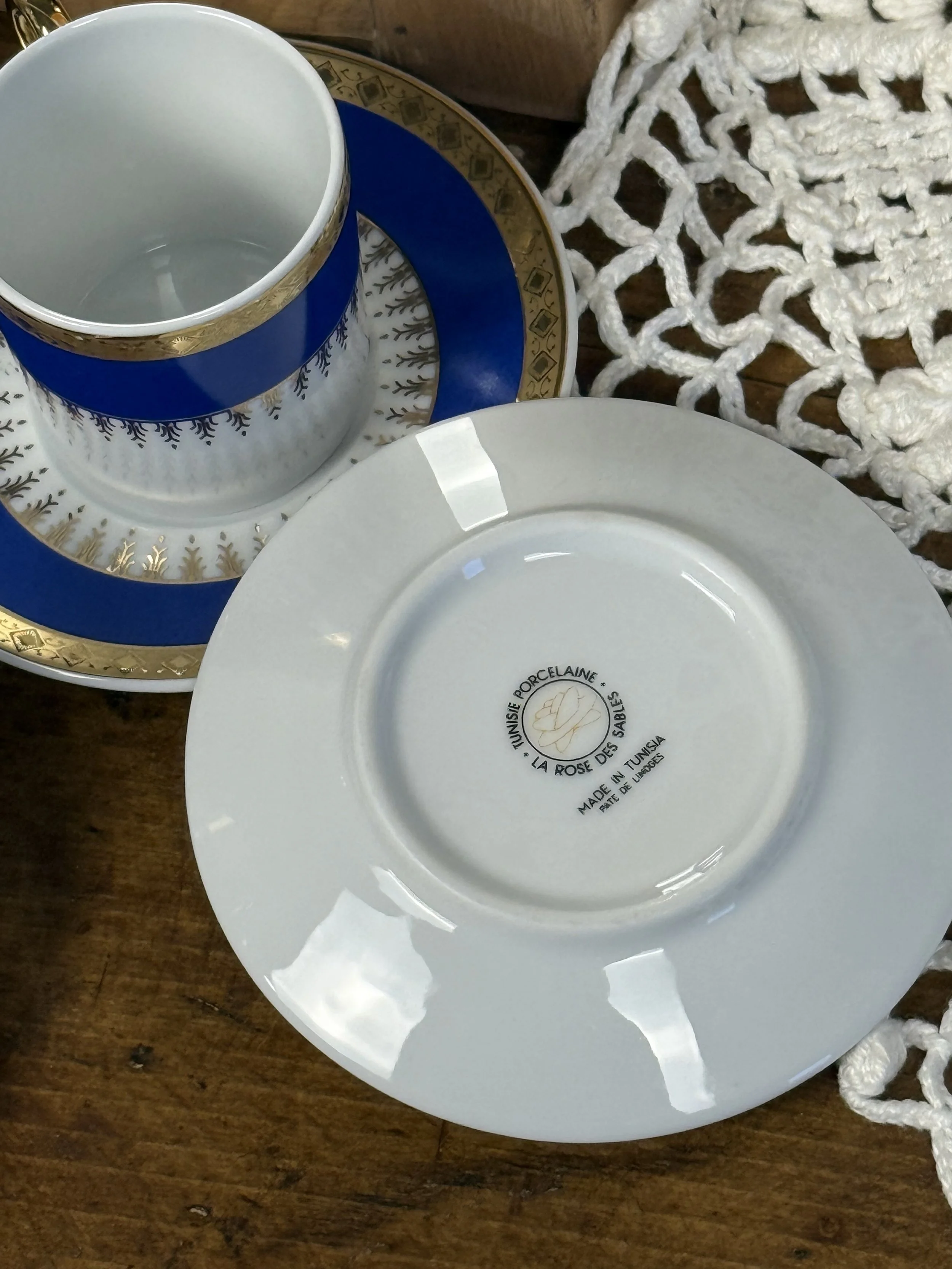 Underside of vintage porcelain saucer with maker’s mark visible, smooth white glaze and classic European porcelain finish