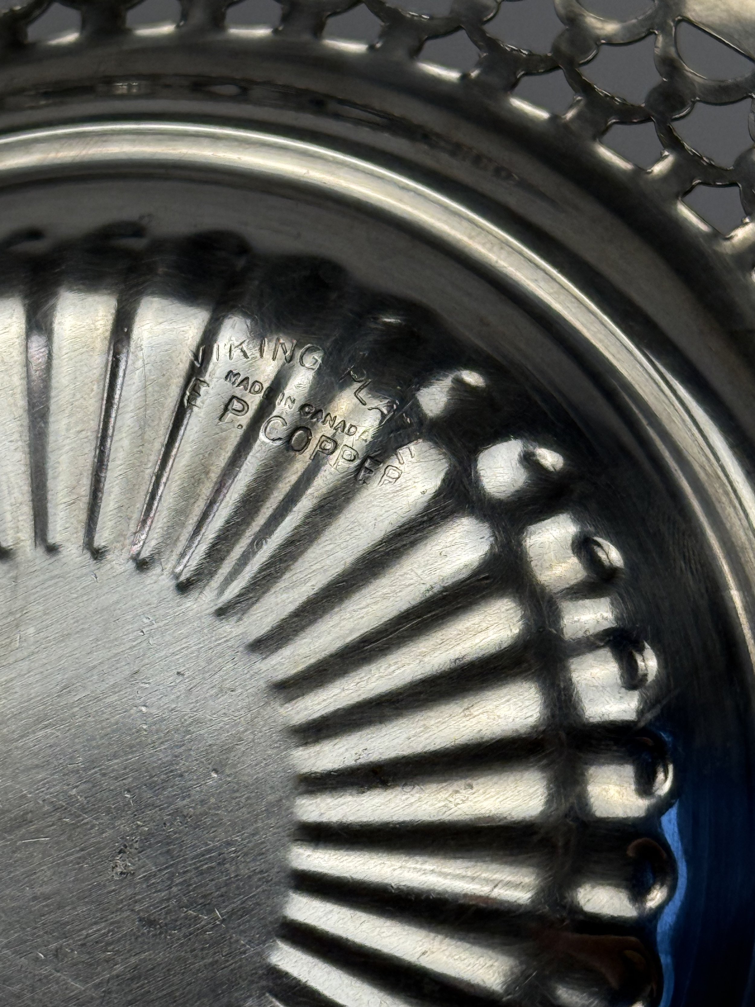 Close-up of vintage EP Copper Viking Plate silverplate showing stamped mark and radial sunburst pattern, mid-century metal serving dish