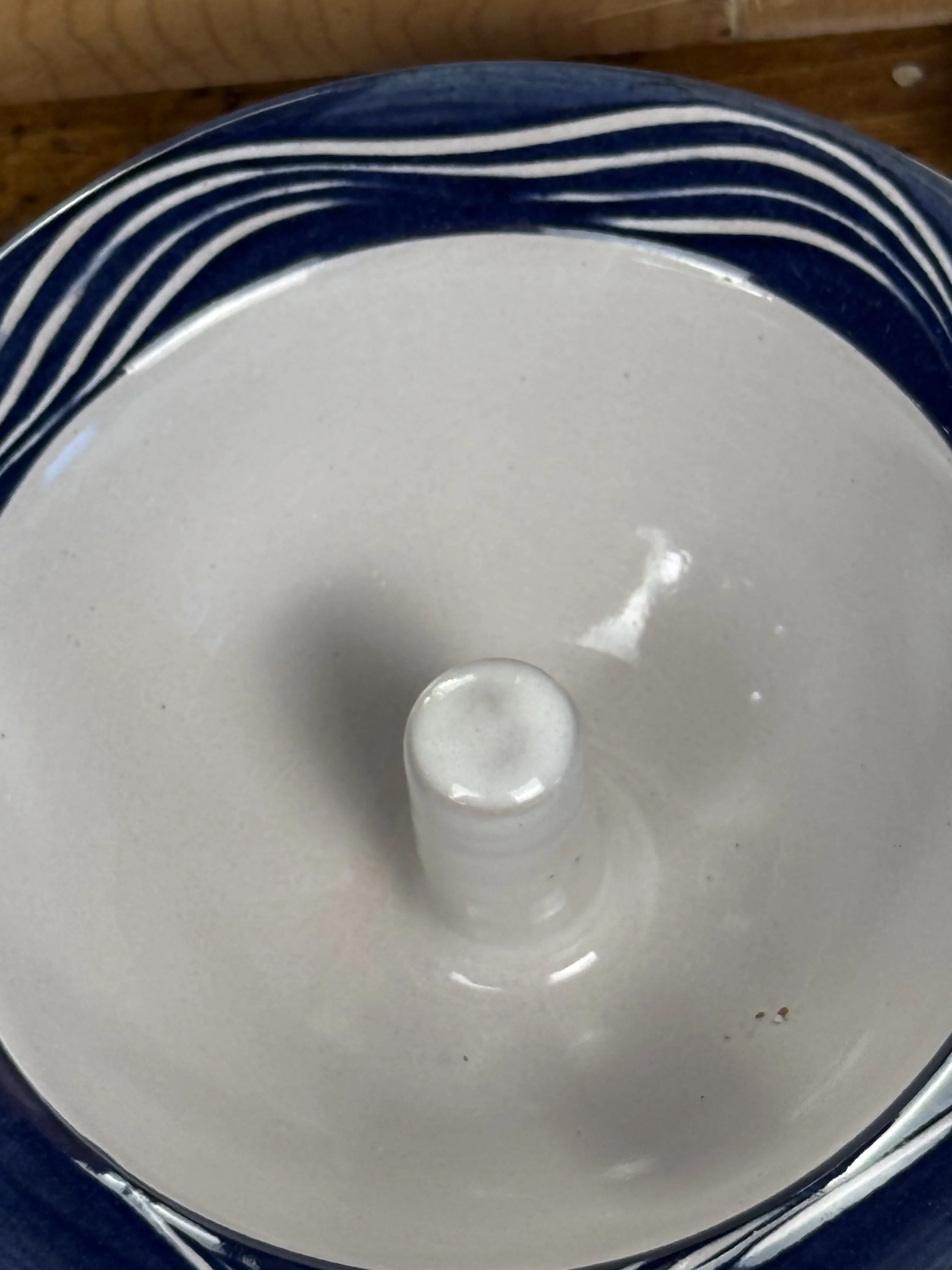 Underside of vintage terracotta apple baker showing impressed maker’s mark, unglazed earthenware base, studio pottery bakeware from Paris, Maine, USA
