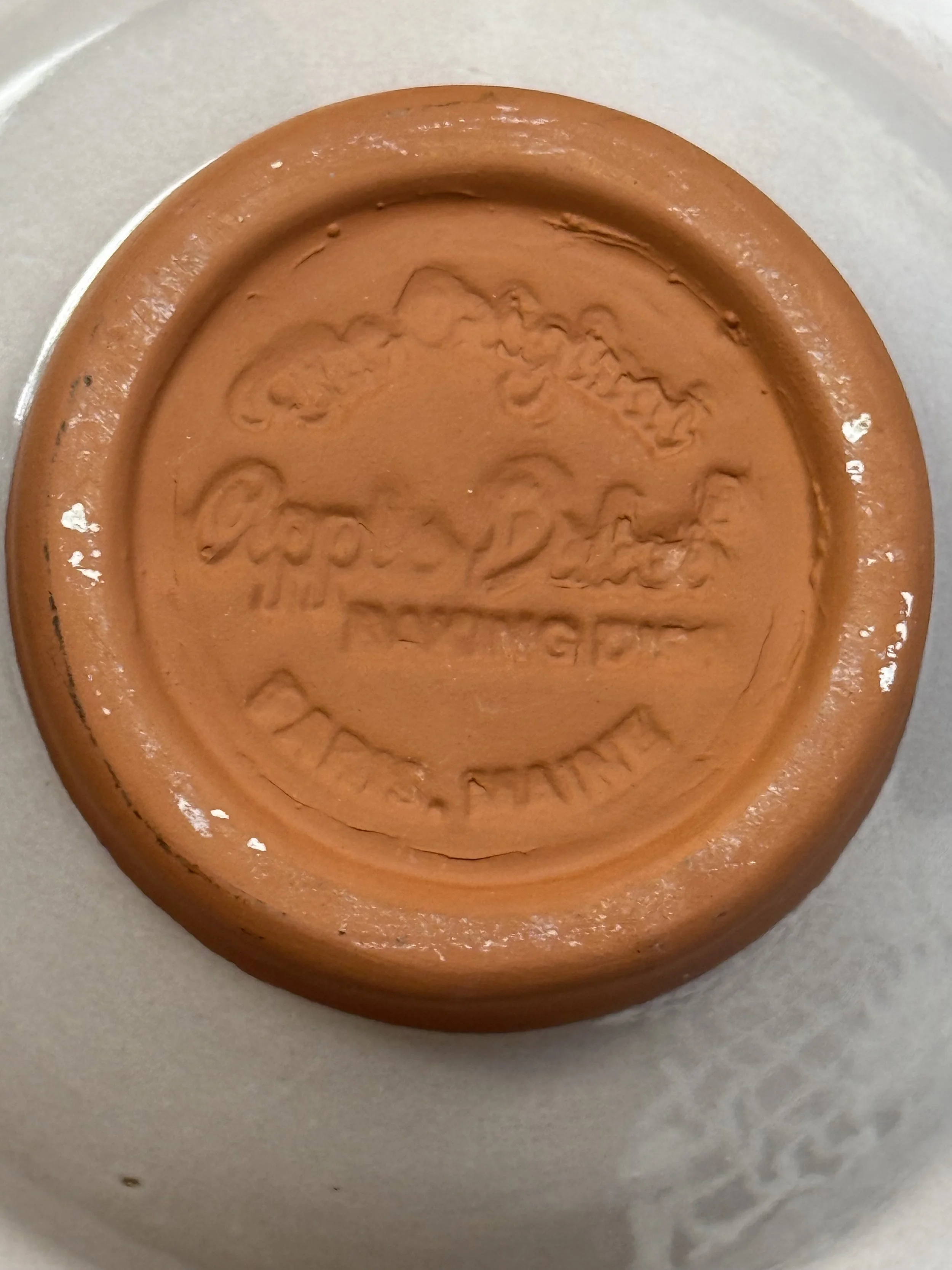 Back view of vintage apple baker highlighting terracotta foot ring and glaze transition, rustic North American earthenware baking dish