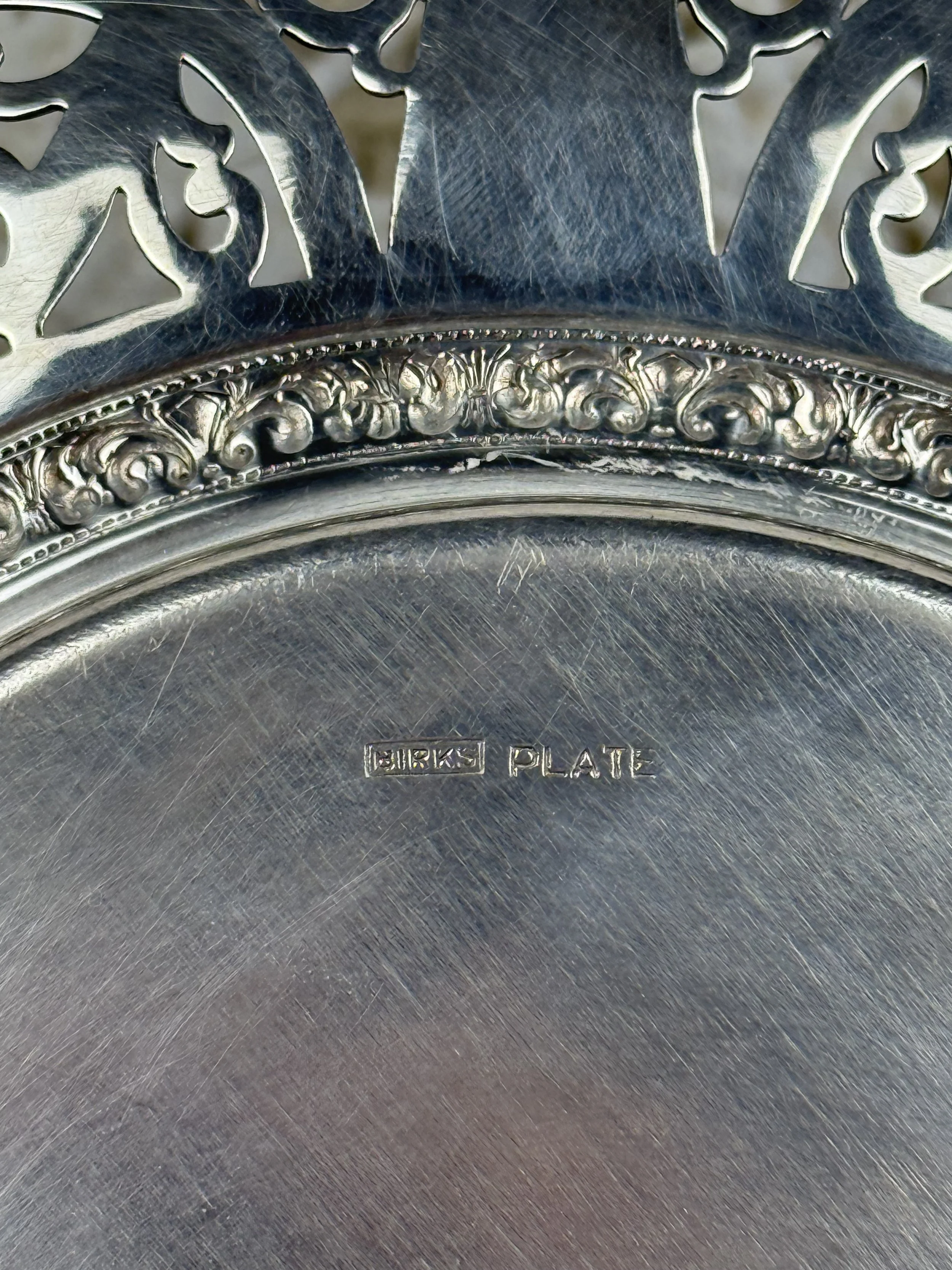 Close-up of Birks silverplate serving plate hallmark stamped Birks Plate, brushed silver surface with fine age-related scratches