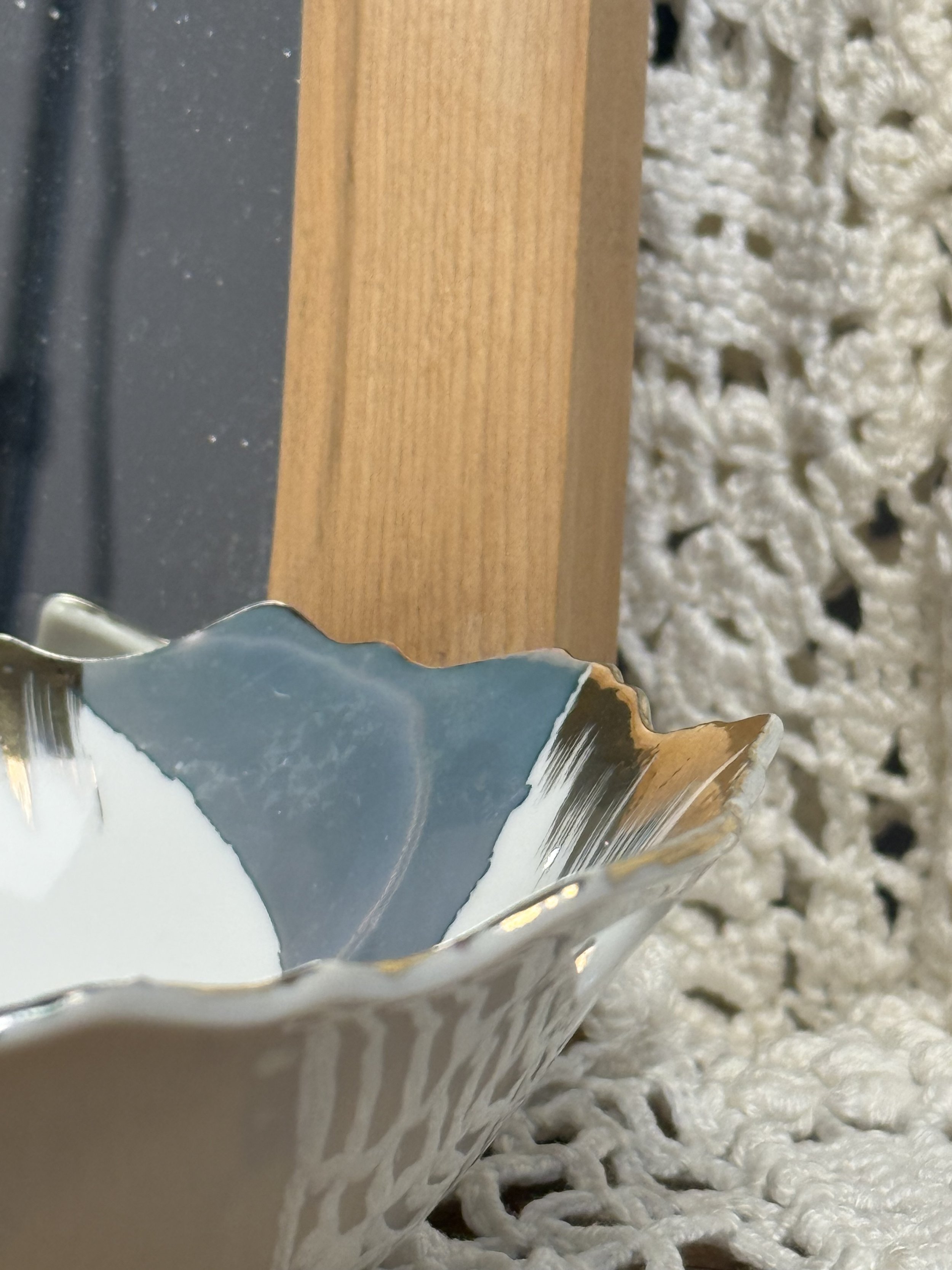 Side profile of scalloped vintage porcelain plate showing gold-trimmed edge, layered glaze application, and gentle curvature of decorative floral plate