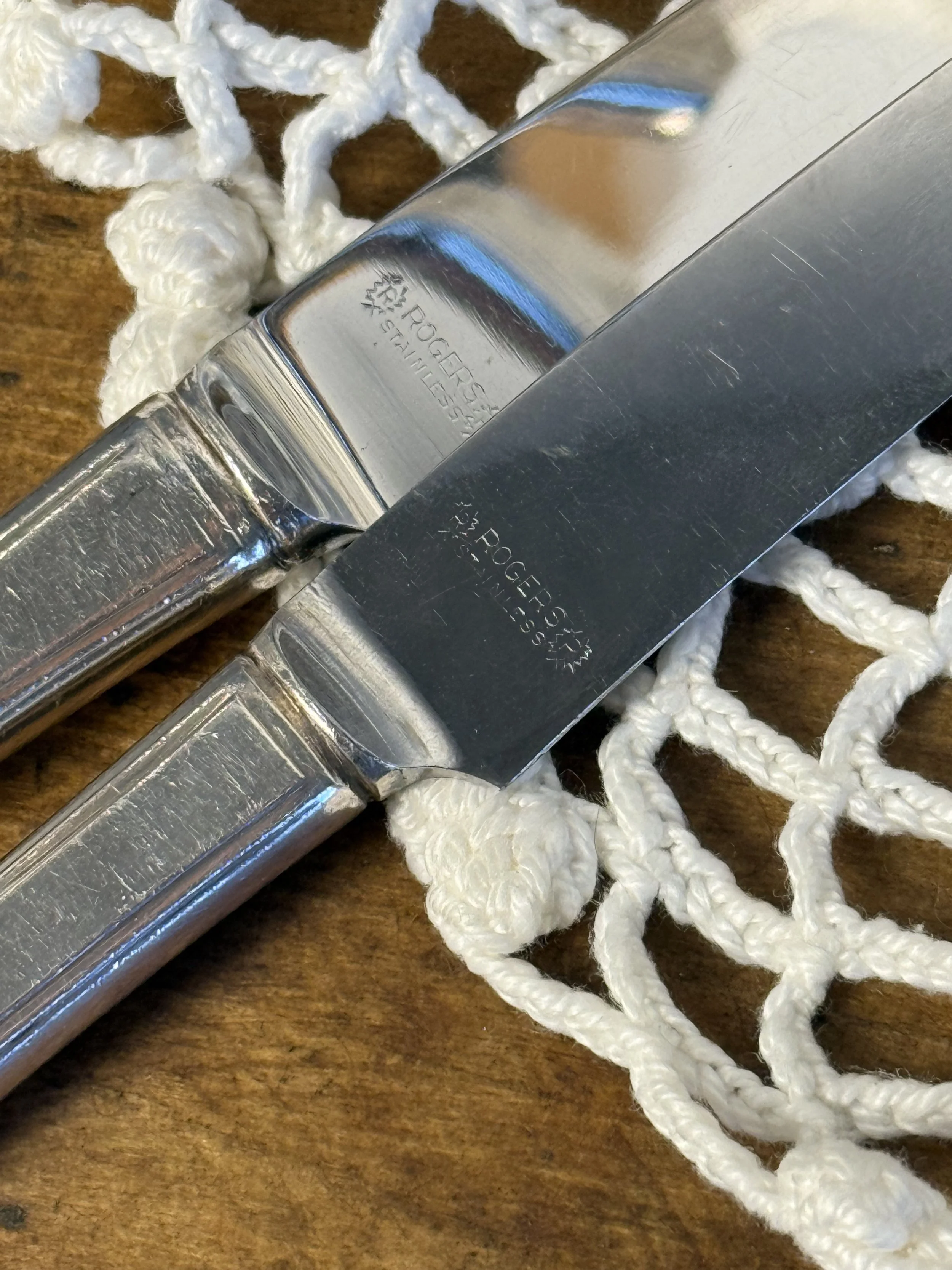 WM A Rogers silver-plated knife blades with maker’s mark, stainless steel flatware close-up