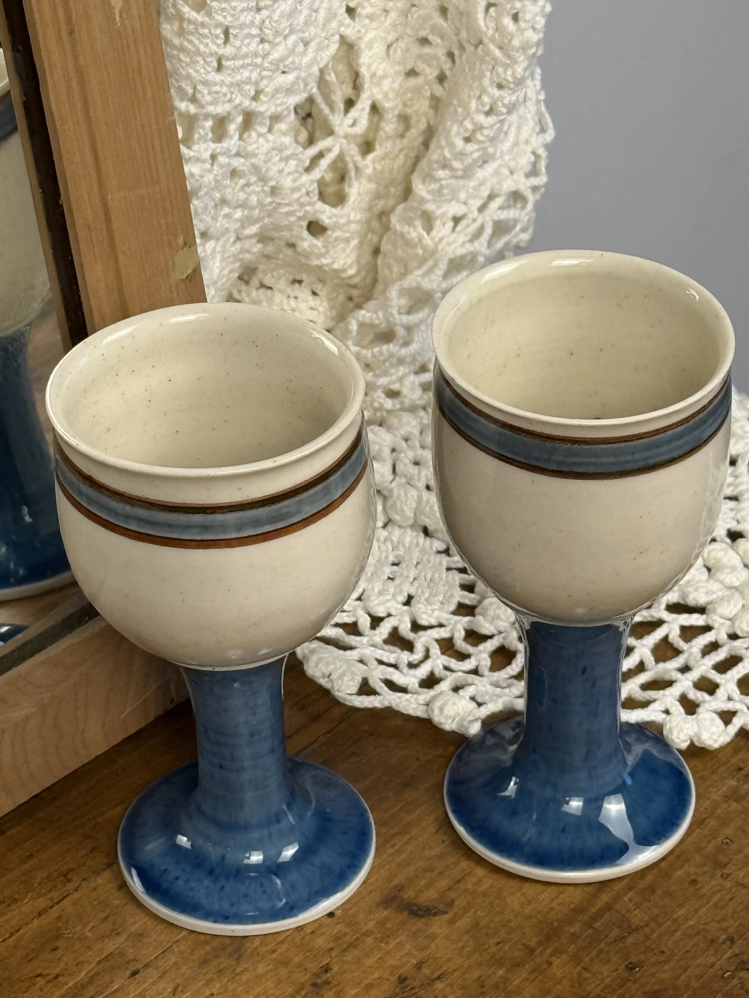 Pair of vintage stoneware goblets, cream and blue ceramic drinkware, handcrafted pottery cups displayed together
