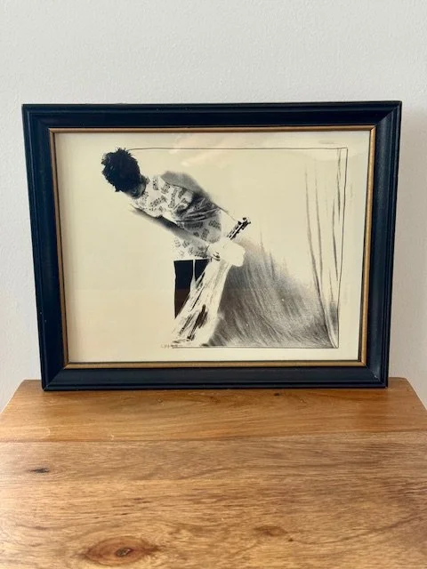 Framed black and white vintage art print depicting an abstract female figure in motion, mid-century modern style, set in a black wood frame with gold inner trim, minimalist wall art