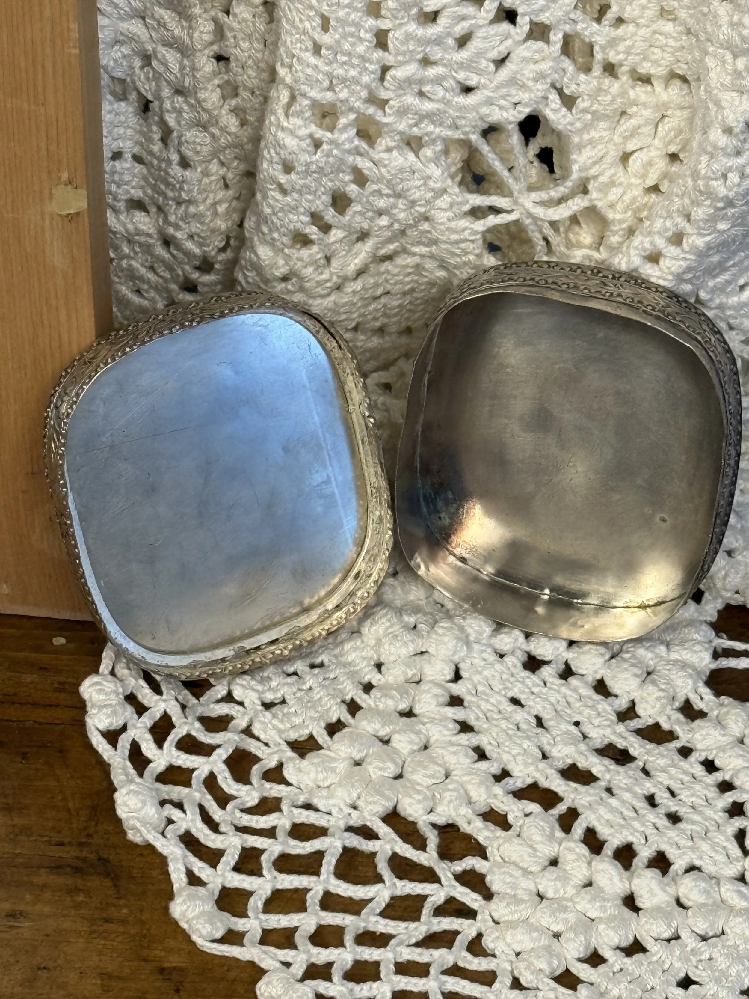 Silver-toned metal interior of vintage trinket box with softly aged patina, hand-formed square shape, antique-style keepsake box interior detail