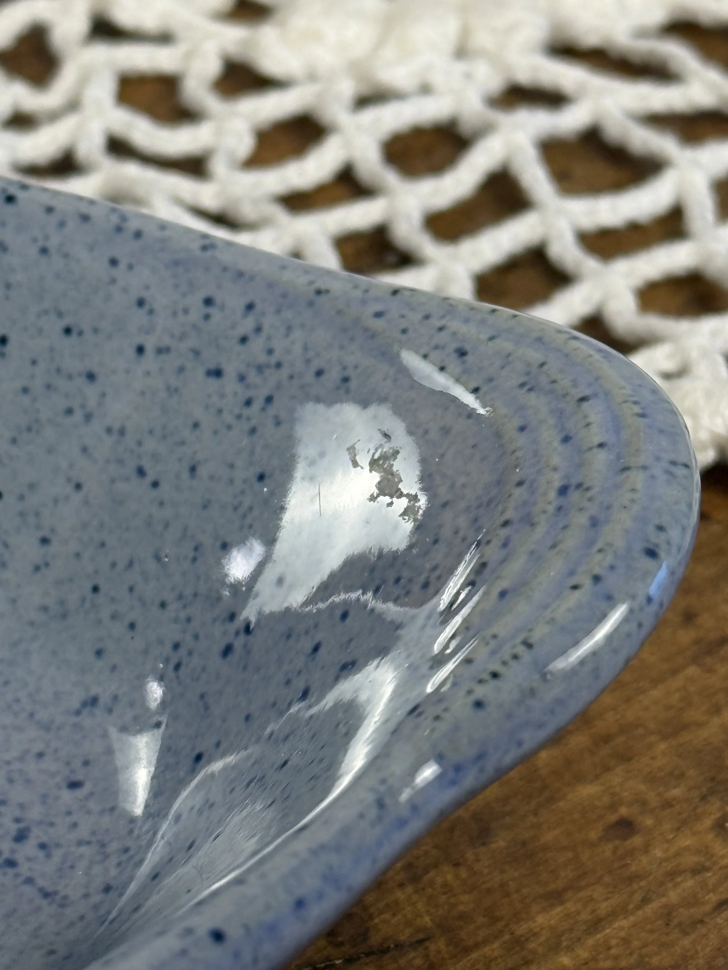 Detail of speckled grey-blue glaze interior on Bakato baked potato dish, showing handmade glaze variation and oval stoneware form