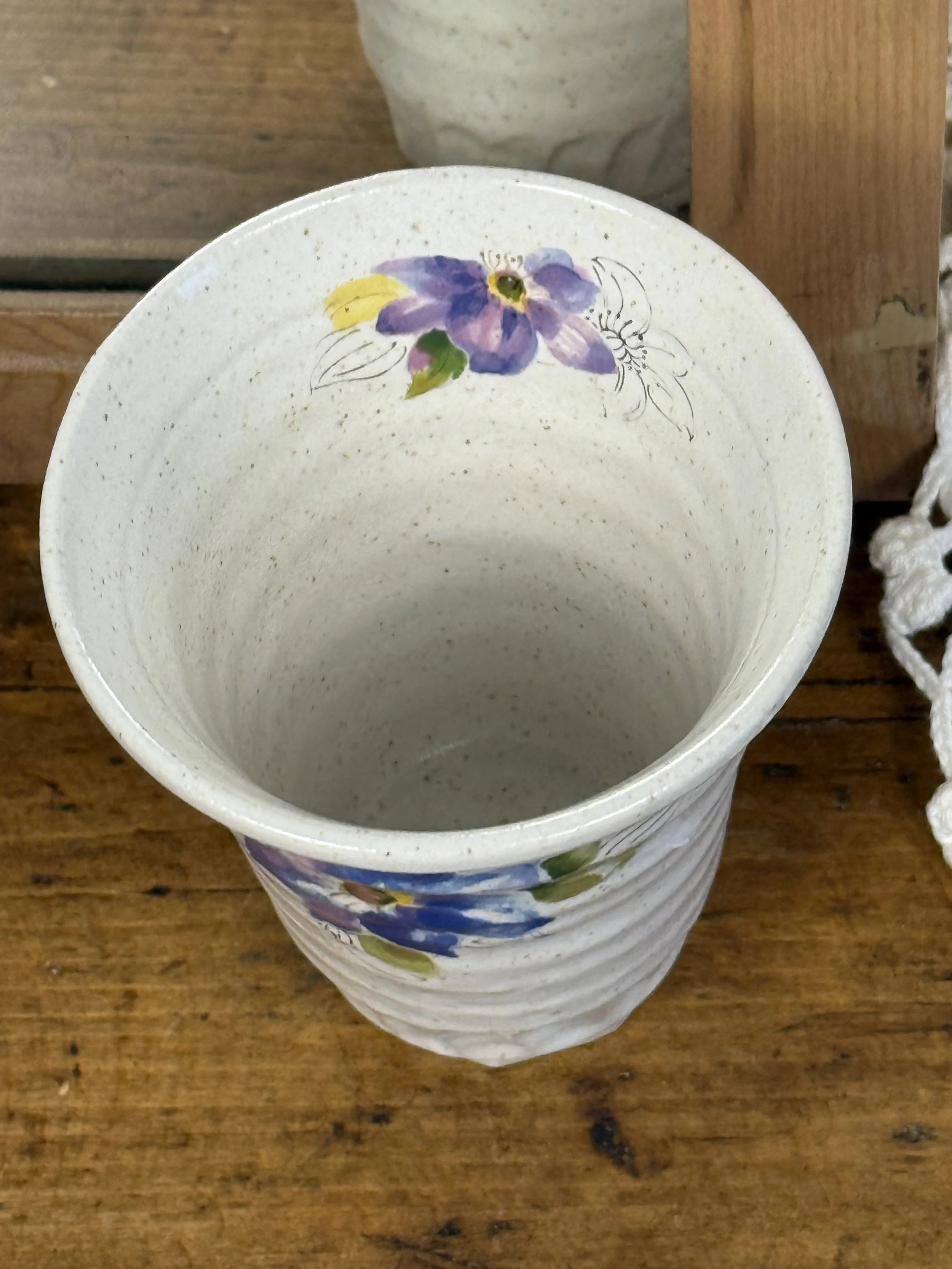 Interior view of Japanese stoneware vase showing speckled glaze, hand-painted floral detail near rim, softly rounded lip