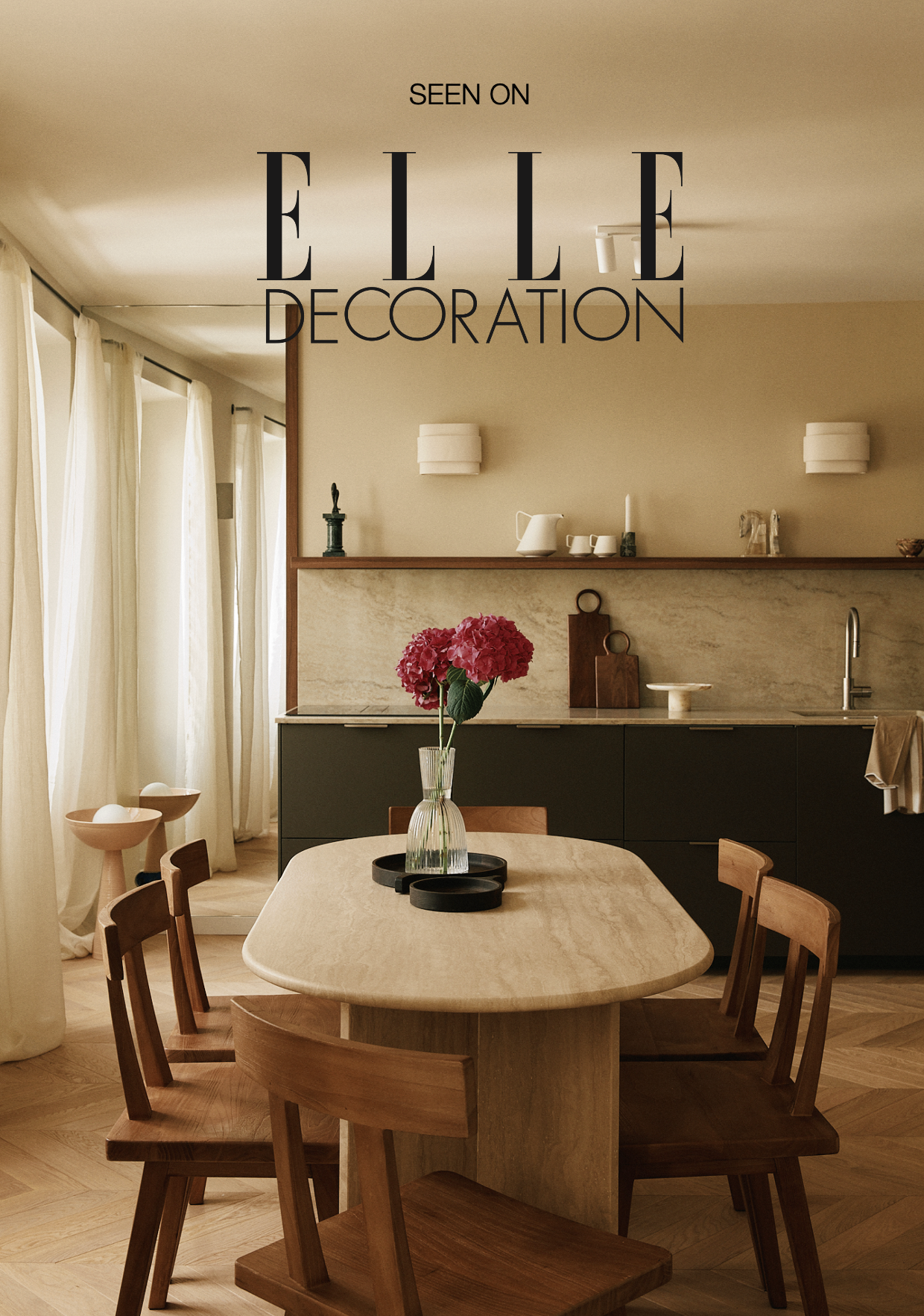 Intérieur de cuisine avec table en bois, vase avec des hortensias roses, rideaux blancs, décor minimaliste.