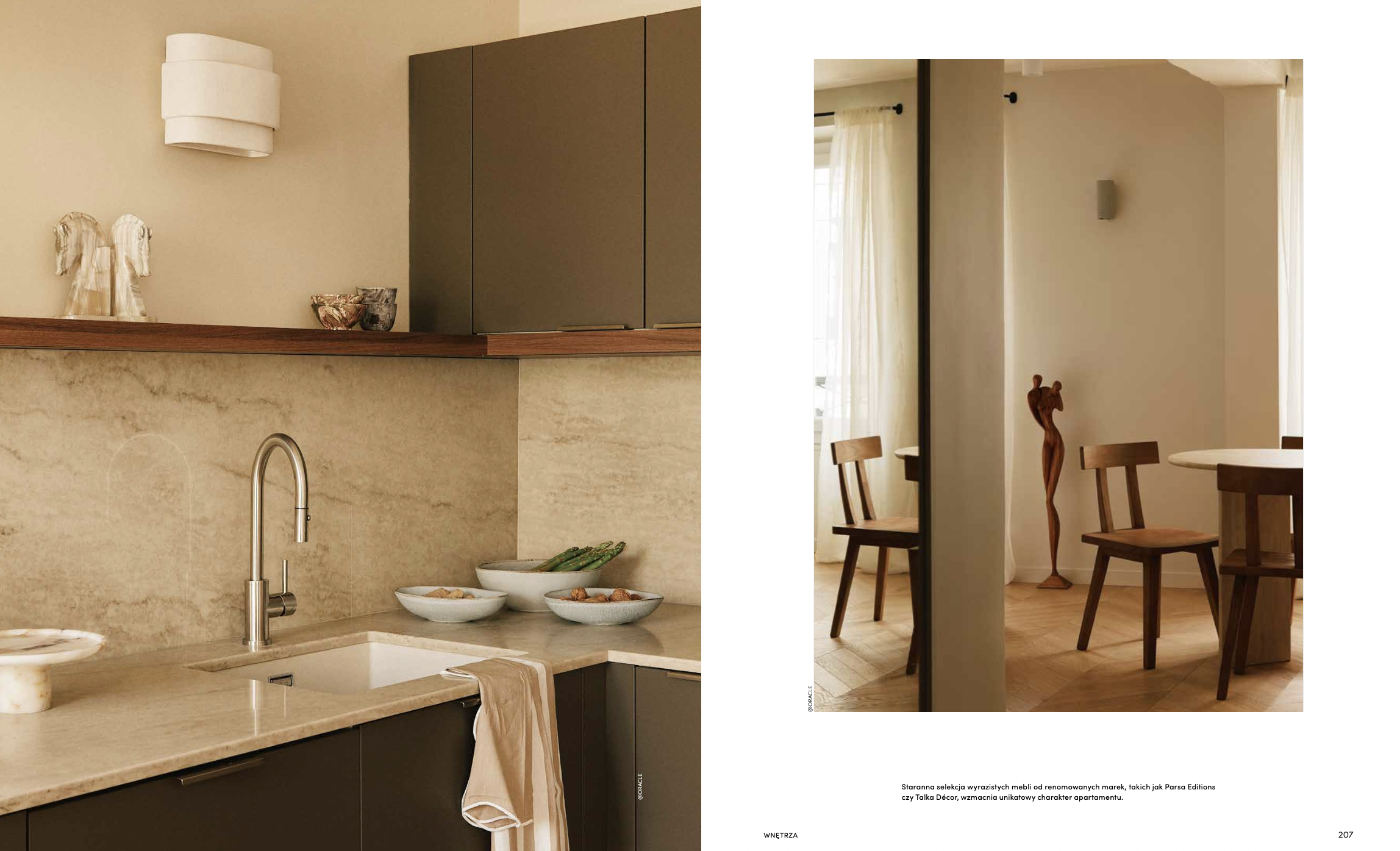 Cuisine moderne avec comptoir en marbre beige, armoires sombres et décoration minimaliste, partie d'un espace de vie contenant aussi une salle à manger avec chaises en bois et sculptures décoratives.