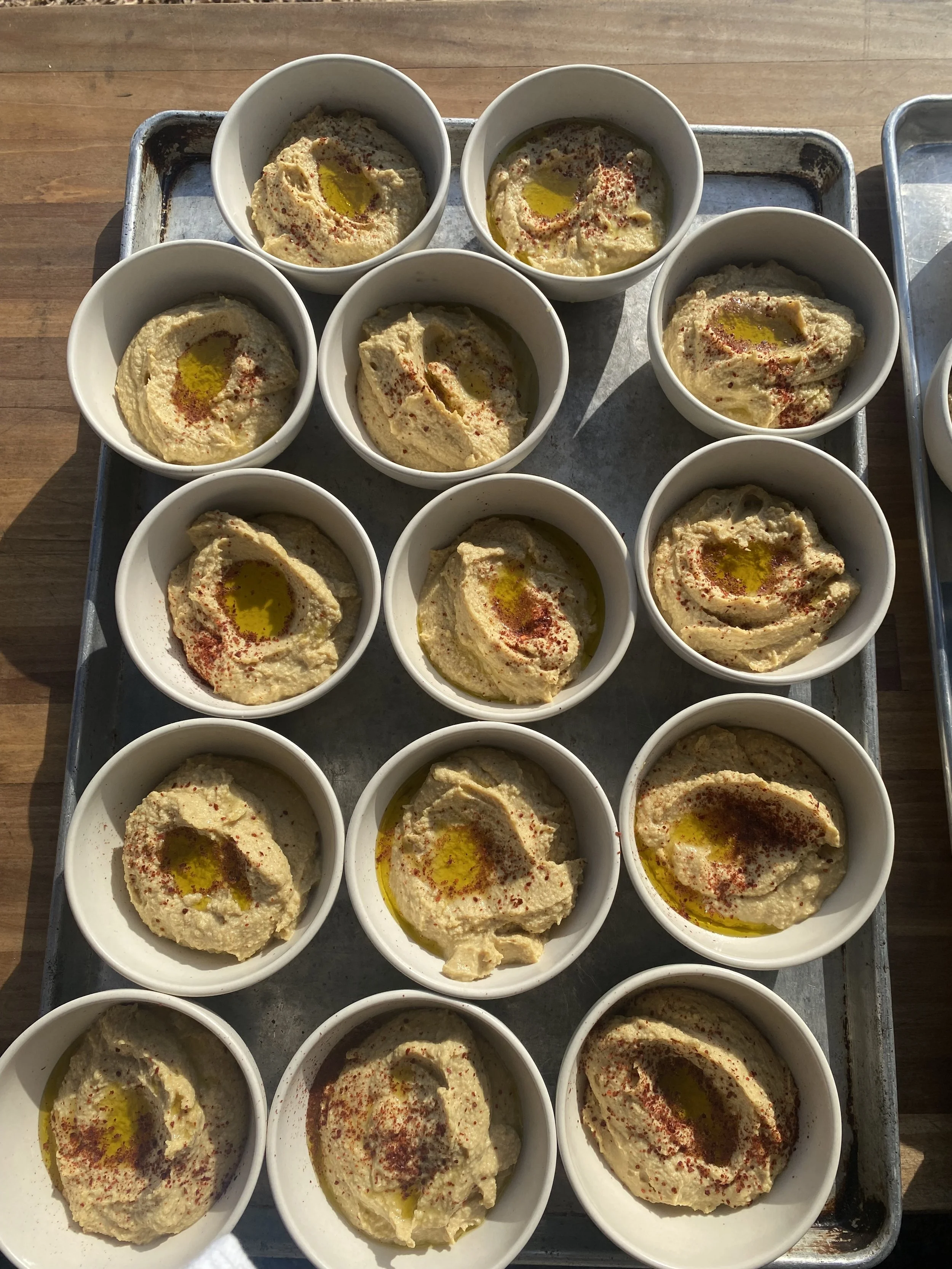 Bowl of hummus garnished with paprika and drizzled with olive oil