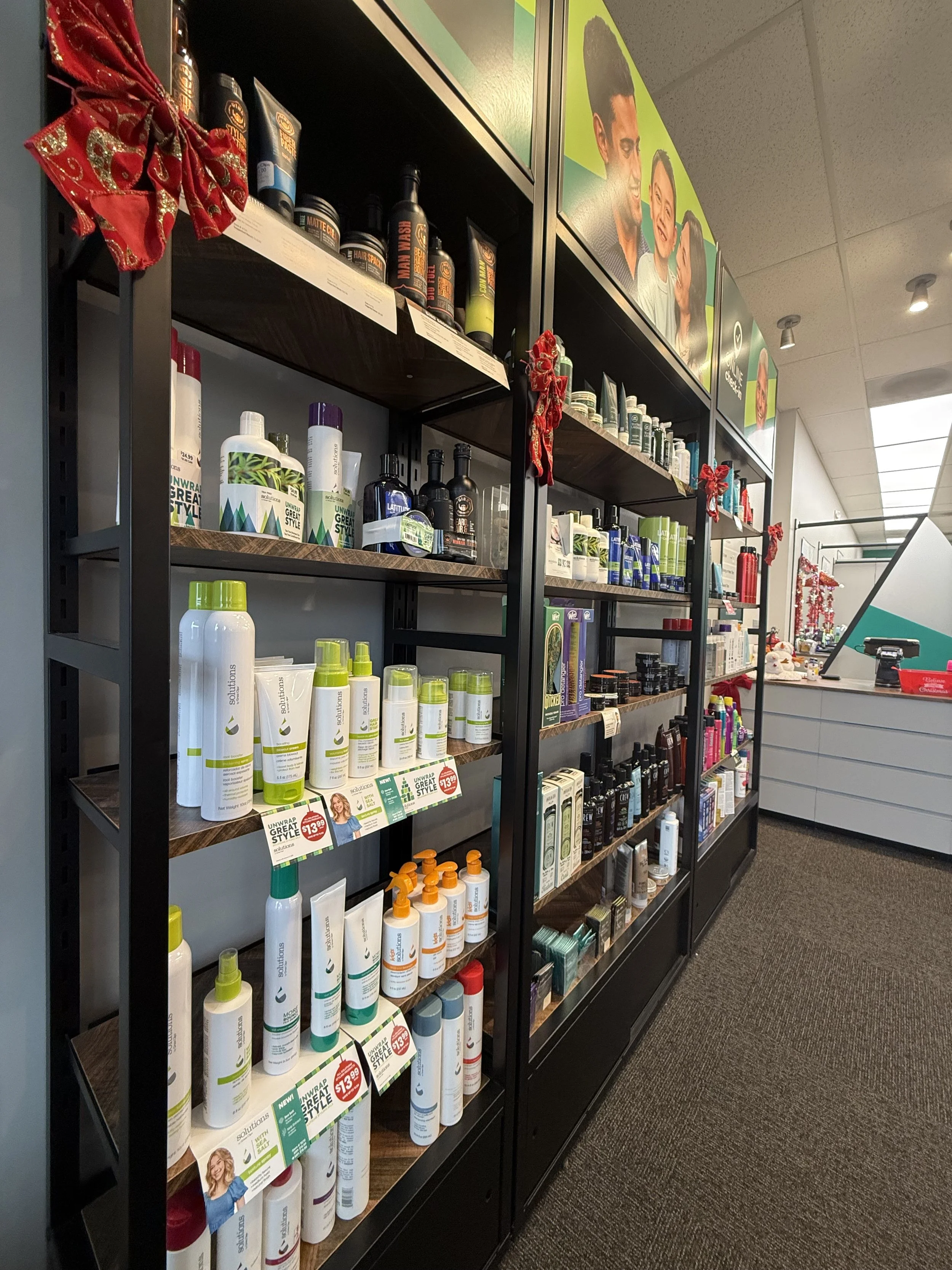 Shelves of skincare and hair care products in a retail store, decorated with red holiday bows.