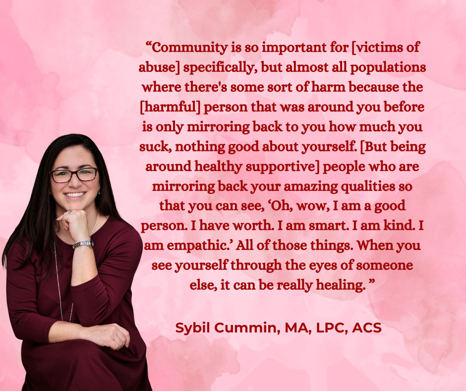 A woman with long dark hair, glasses, wearing a maroon dress, smiling, with her hand resting near her chin, sitting against a pink watercolor background next to a quote about community and healing.