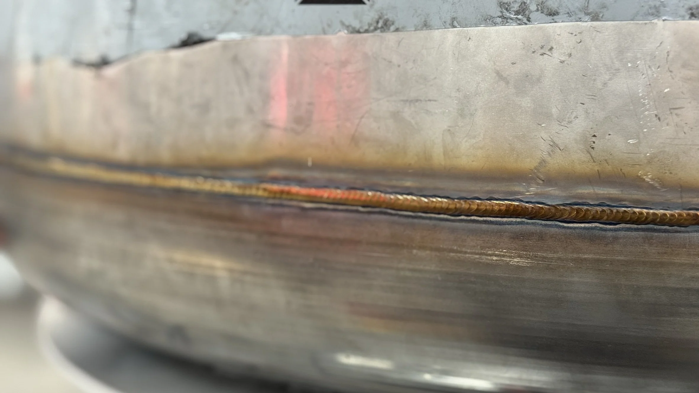 Close-up of a metal surface with a visible weld bead in the center.