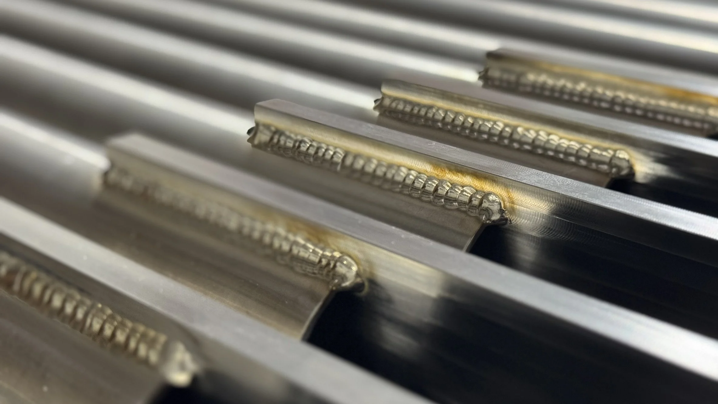 Close-up of metal welding joints on a series of metal beams or plates.