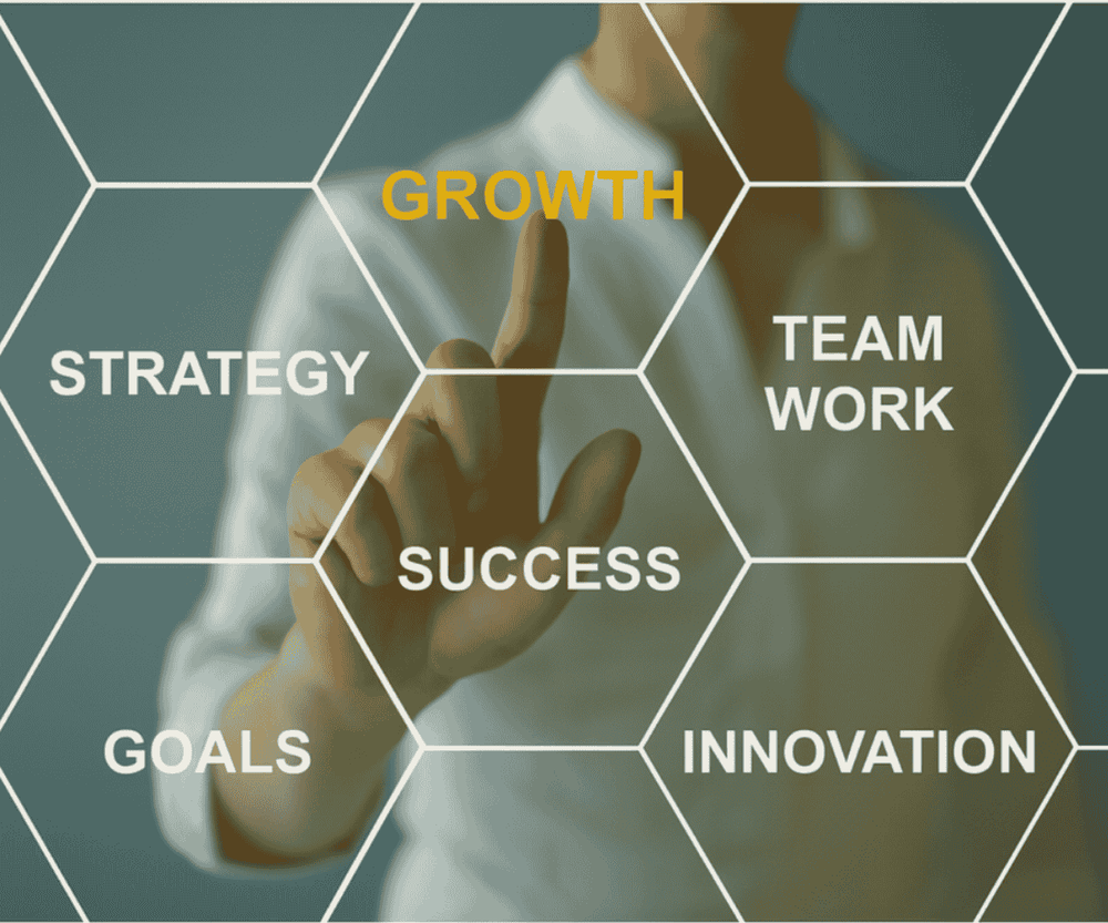 A person in a business shirt interacts with a digital hexagonal grid displaying words like 'Strategy,' 'Goals,' 'Growth,' 'Success,' 'Teamwork,' and 'Innovation.'