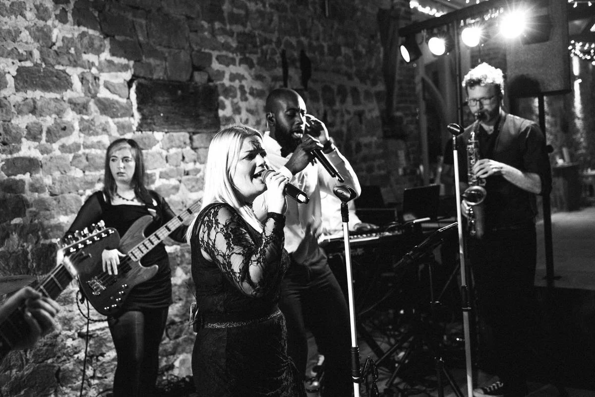 Full wedding band performing live with singers and saxophonist at Tithe Barn Symondsbury Dorset barn reception entertainment