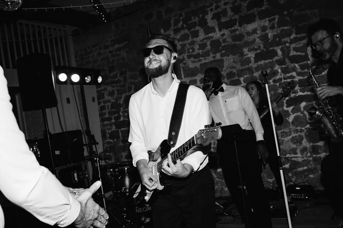 Guitarist performing with wedding band at Tithe Barn Symondsbury Dorset during lively barn reception entertainment