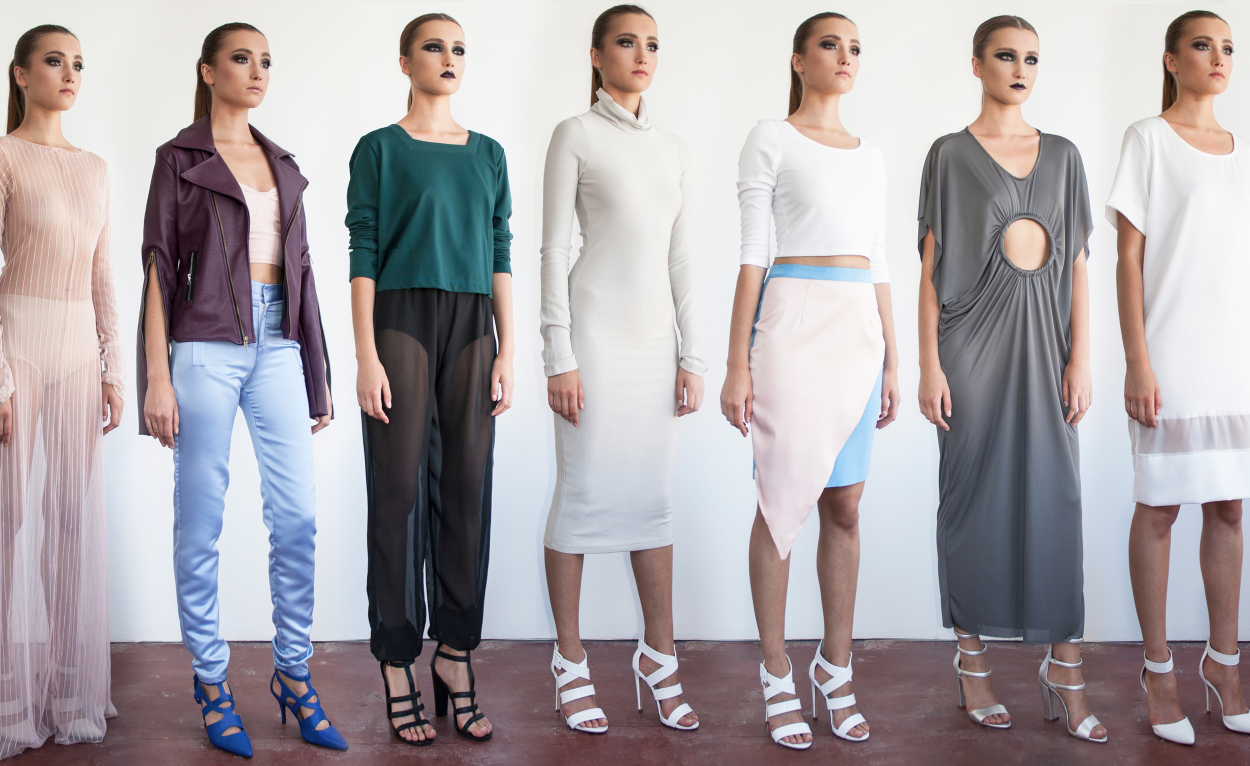 Seven women standing in a row, wearing fashionable clothes and high heels, against a plain white background.
