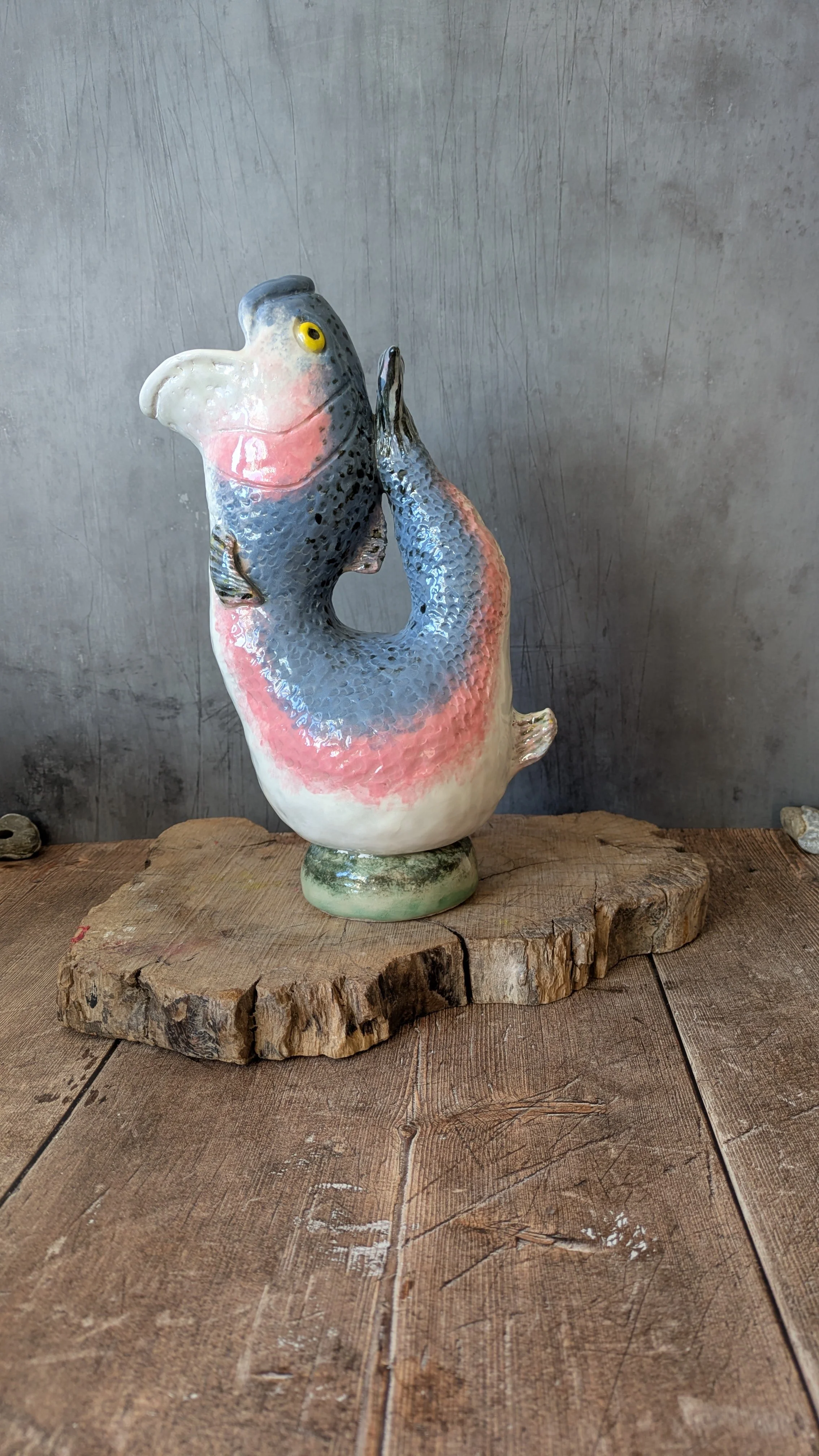 A handmade ceramic jug made in the image of a rainbow trout