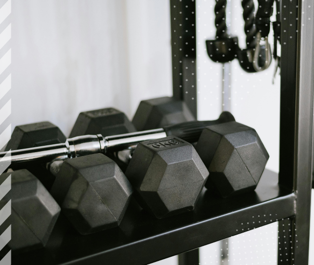 Hantlar och en skivstång i ett gym.