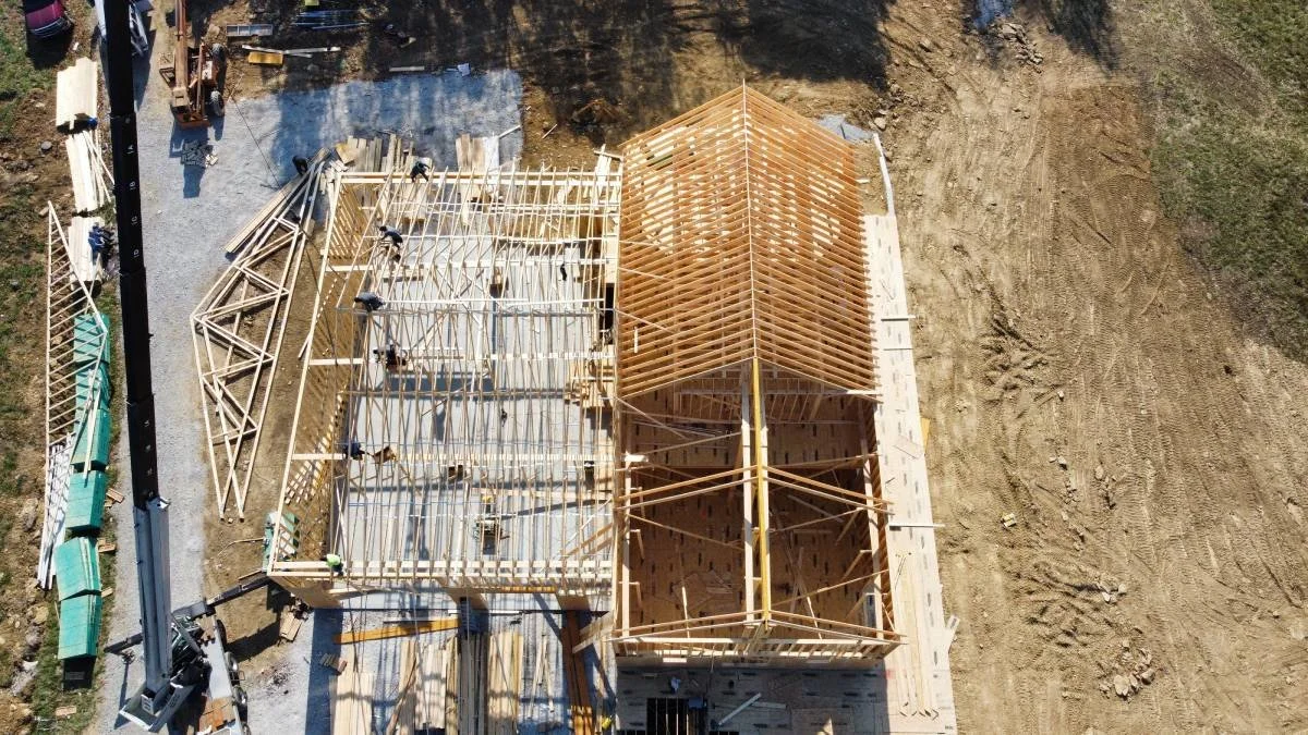 Aerial view of a custom home's poured foundation and wall framing during construction in Central Kentucky.
