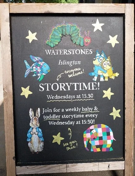Blackboard sharing information about Waterstones Islington weekly free baby and toddler storytime, illustrated with famous children's book characters